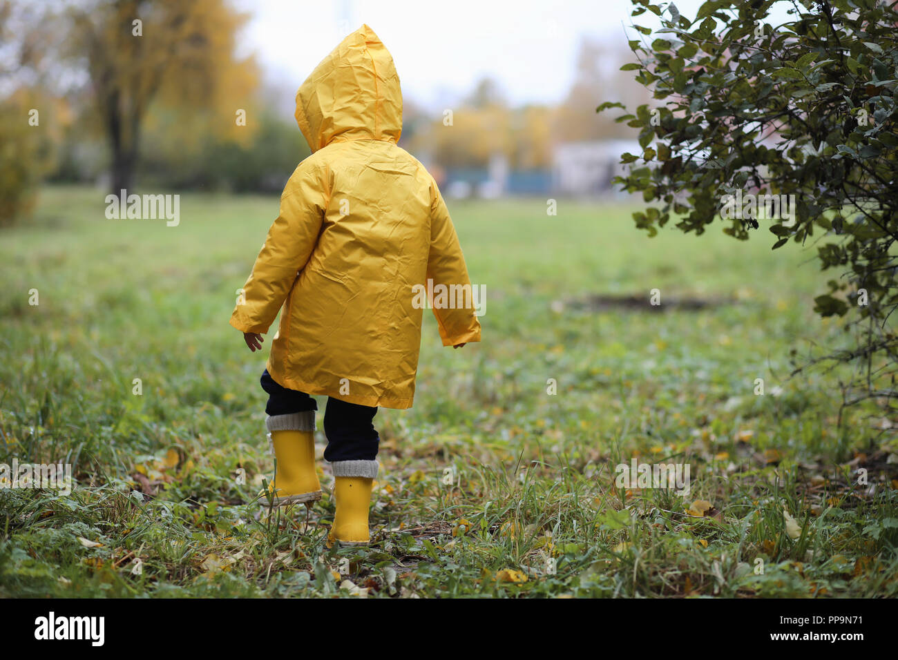 Un enfant dans un imperméable pour une promenade à l'extérieur Photo Stock  - Alamy