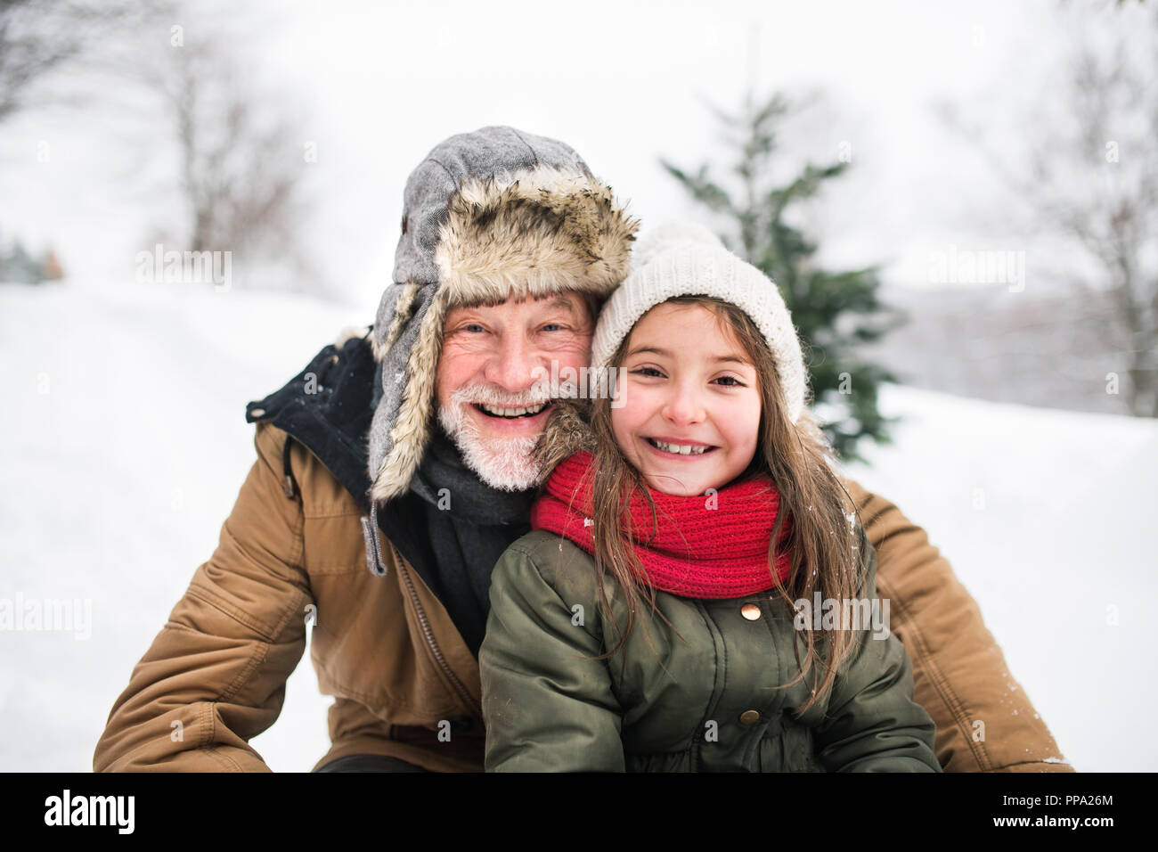 Grand-père et la petite fille dans la neige sur une journée d'hiver. Banque D'Images