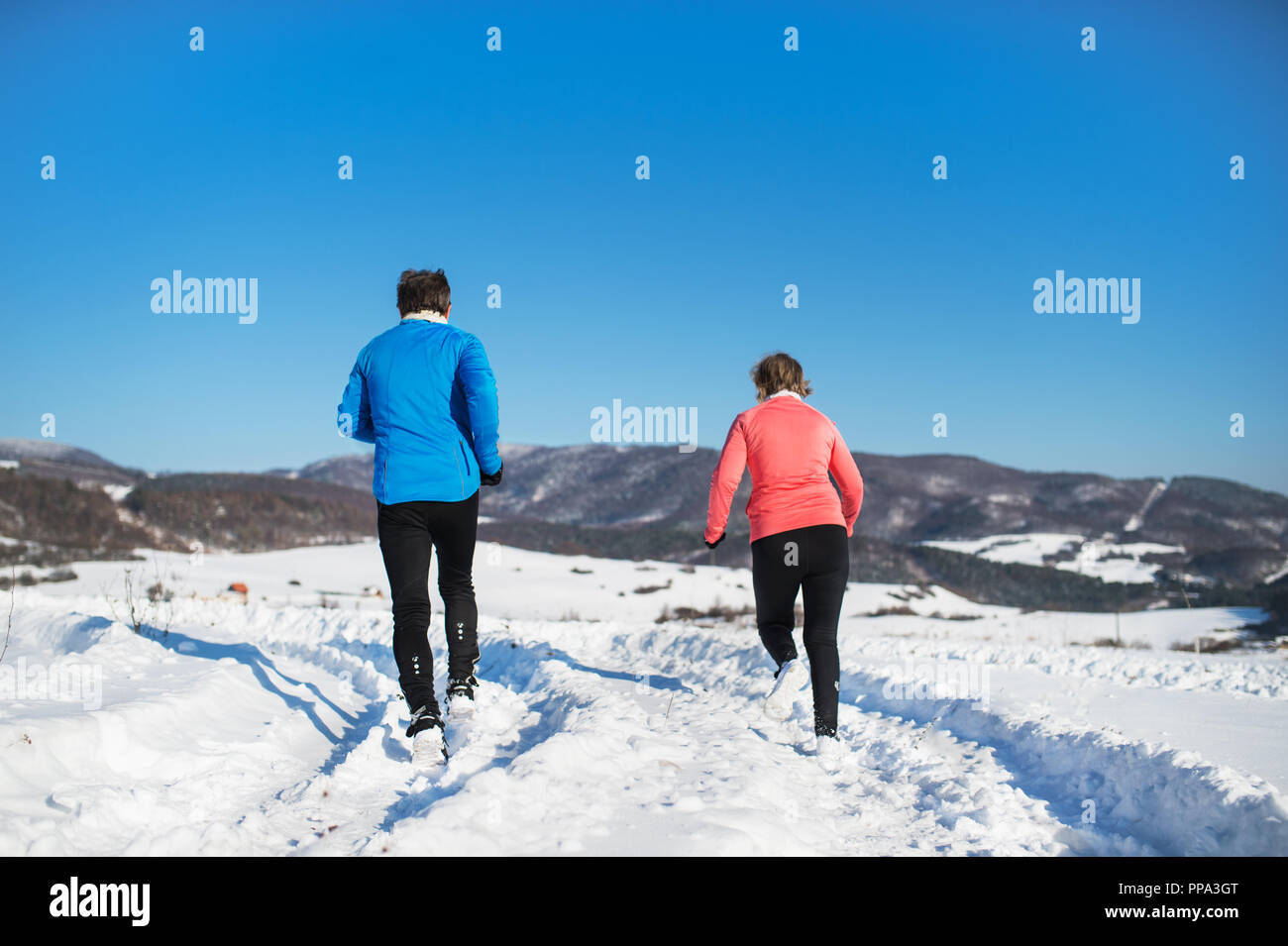 Vue arrière de la haute couple jogging en hiver la nature. Banque D'Images