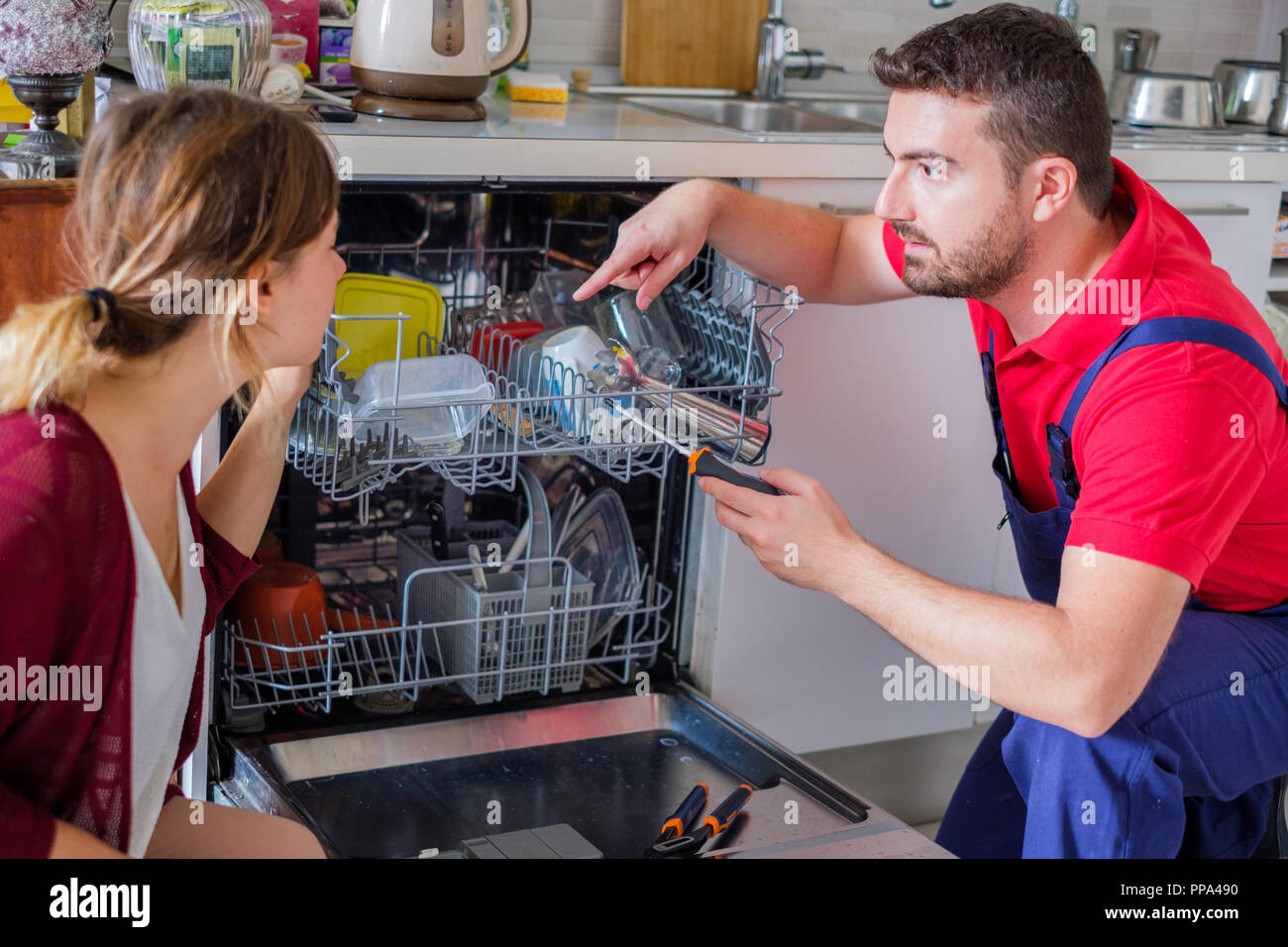 Plombier installation nouveau lave-vaisselle et d'expliquer à la femme au  foyer Photo Stock - Alamy