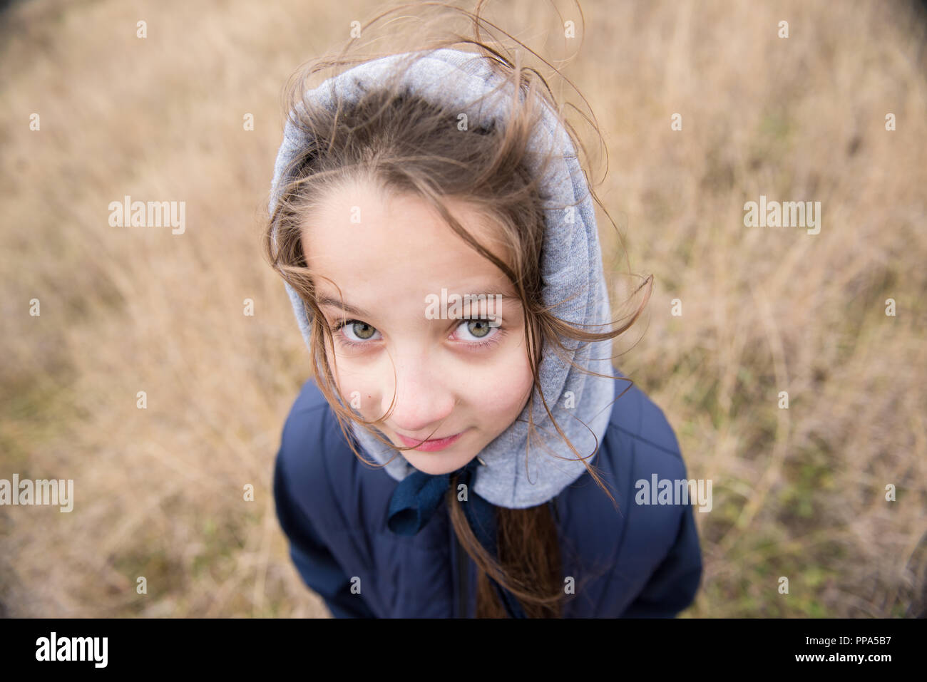 Libre de pretty little girl in hood et veste avec cheveux vent qui souffle la météo Banque D'Images
