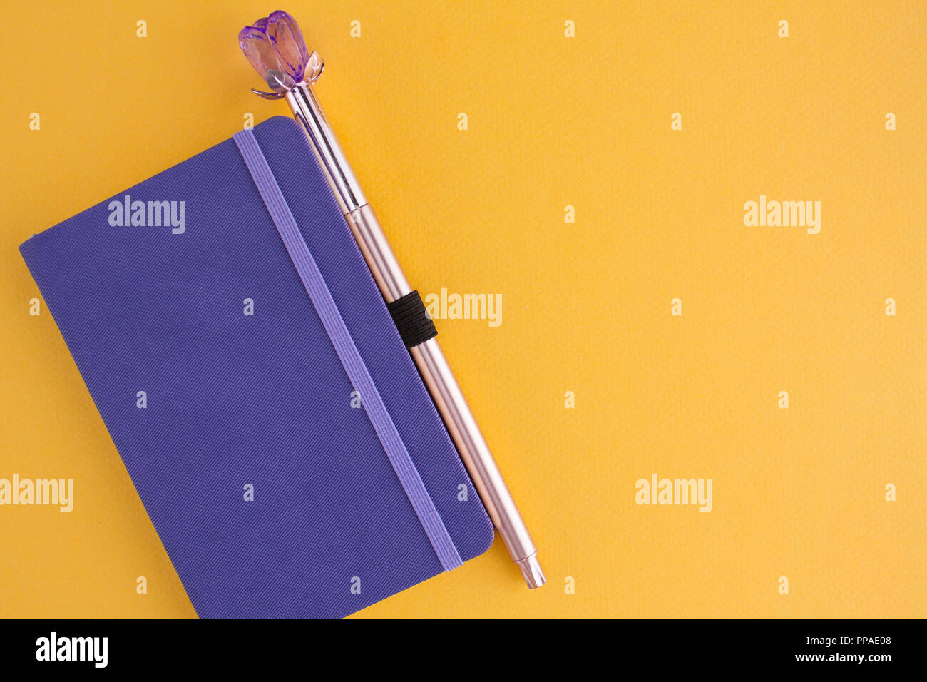 Bloc-notes avec stylo violet sur fond jaune Banque D'Images