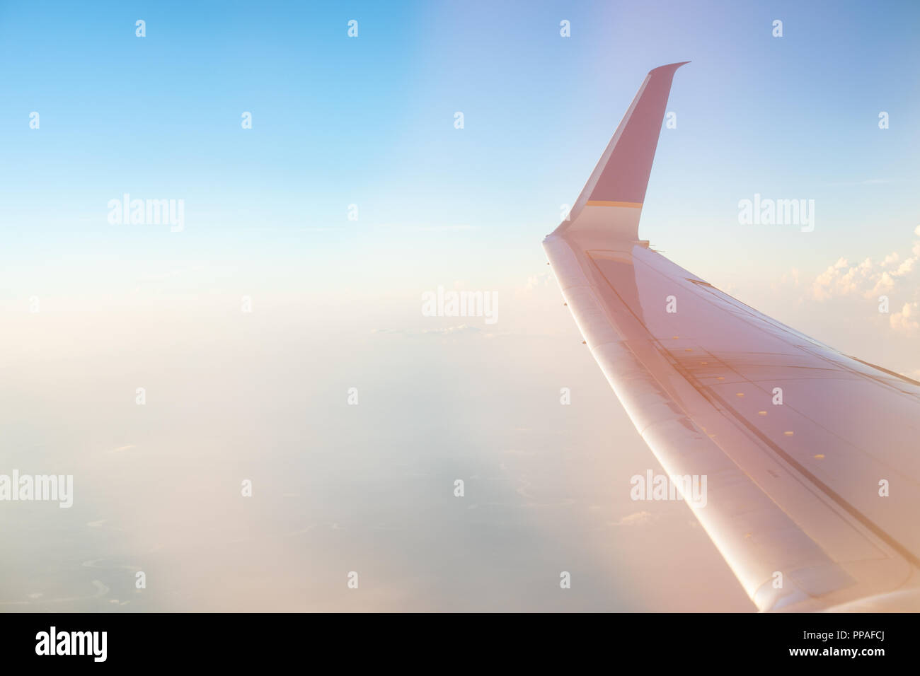 Vue imprenable sur le lever du soleil sur une haute altitude à partir de la vitre du passager d'un avion conventionnel. Le soleil du matin dans le ciel de couleurs pastel. Banque D'Images