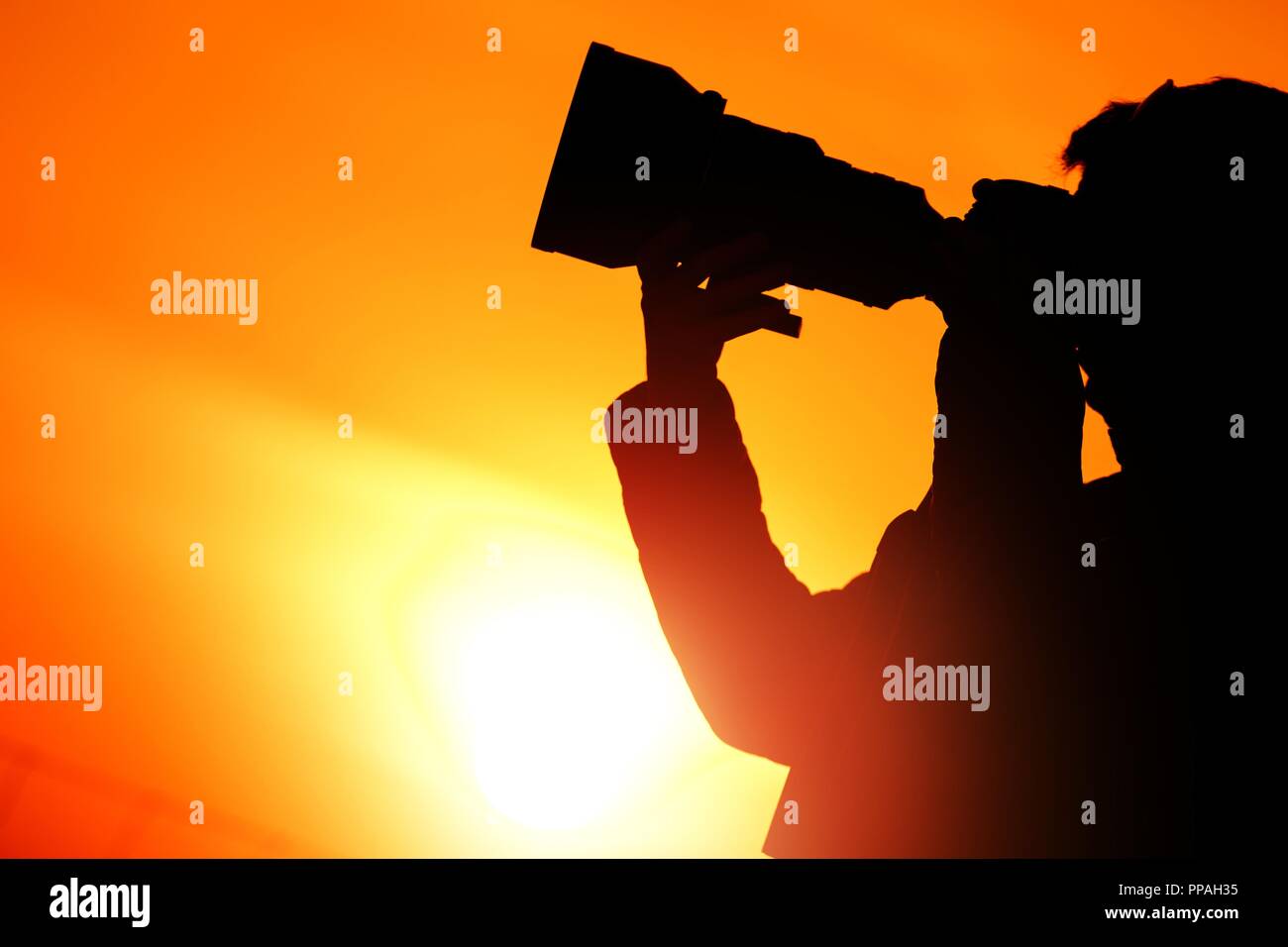 Coucher de soleil photographe Silhouette. Prendre des photos pendant l'heure d'or. Banque D'Images