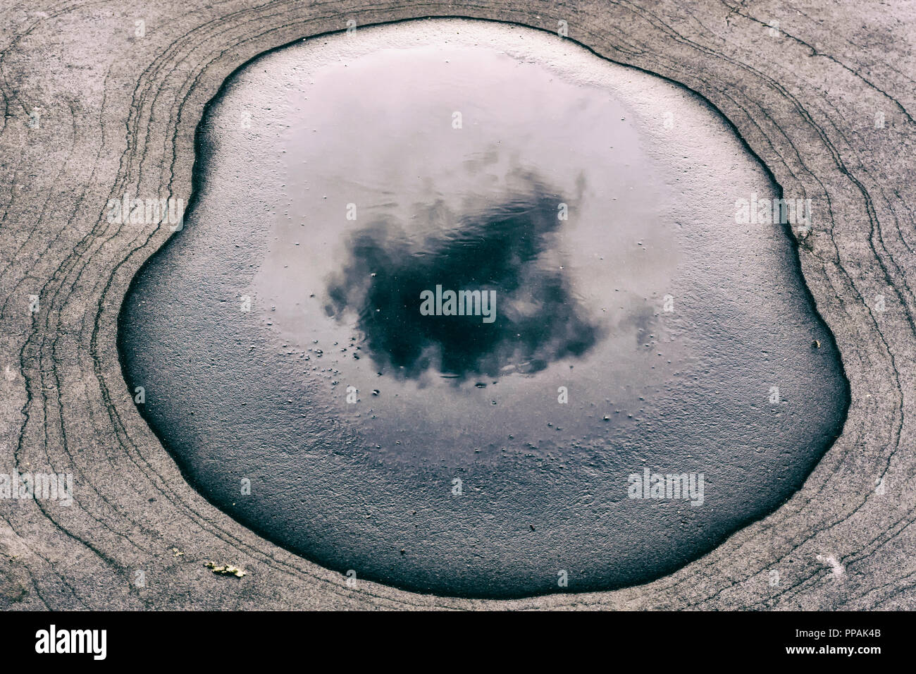 Berlin, Allemagne, le 22 septembre 2018 : Portrait de nuage noir reflété dans l'eau de pluie flaque sur un quai de gare Banque D'Images