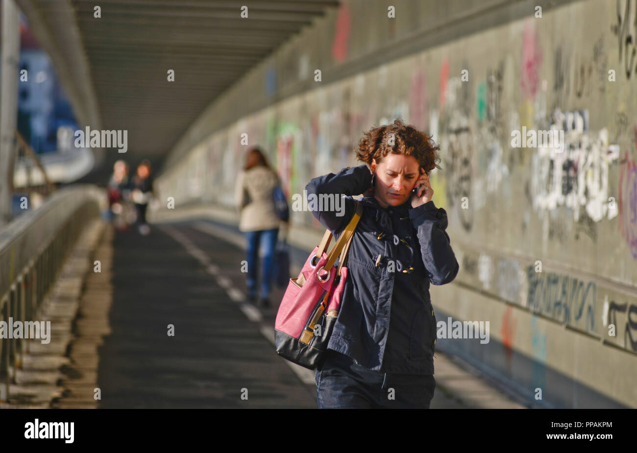 Femme marche et parler au téléphone, la plupart des SNP, Bratislava, Slovaquie Banque D'Images