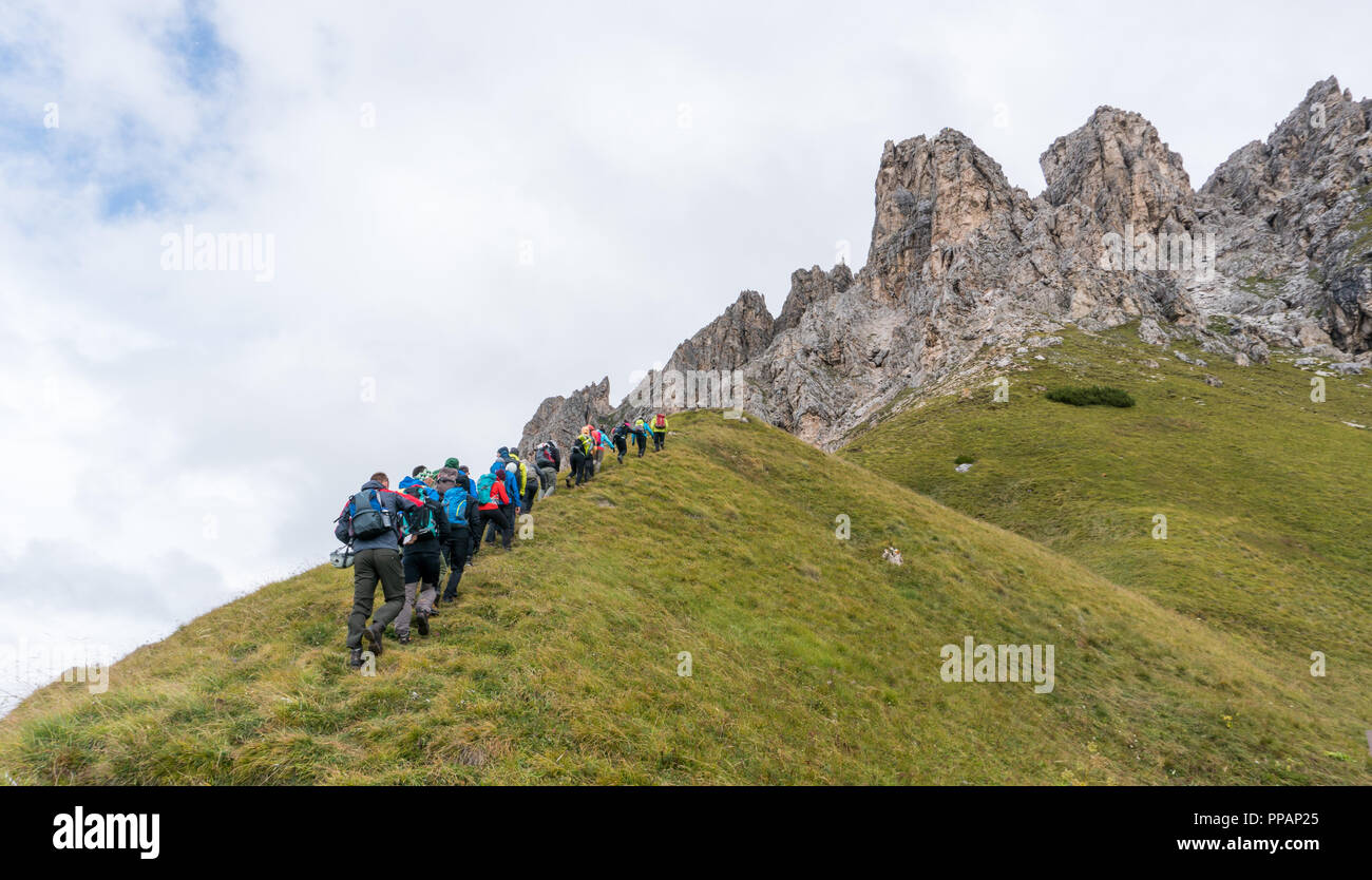 Un grand groupe de grimpeurs et deux guides de montagne Randonnées vers le début d'une escalade dans les Dolomites d'Alta Badia en Italie du nord Banque D'Images