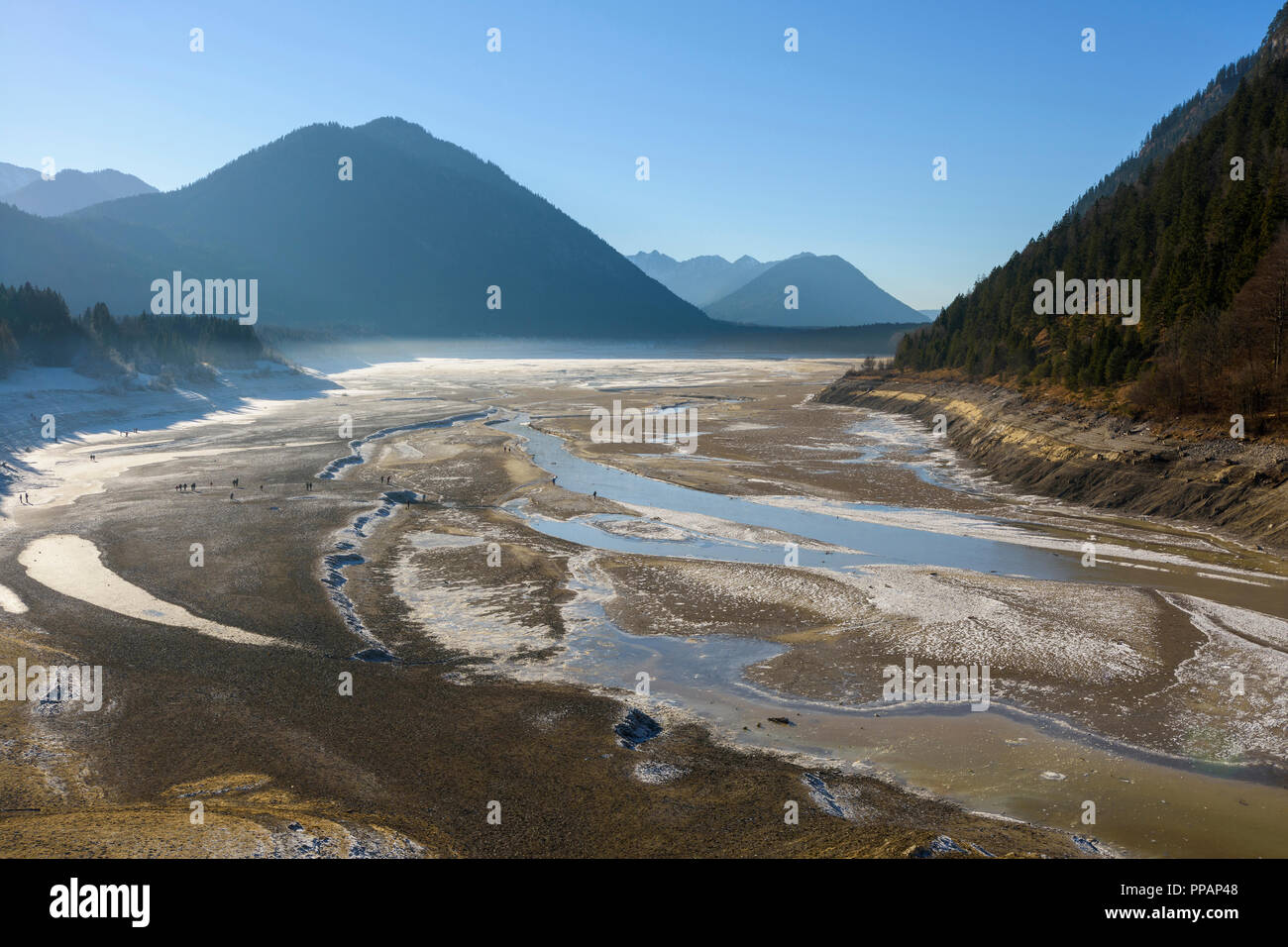 Lac de stockage dégonflé avec touristes en hiver, le lac de Sylvenstein, Isartal, Lenggries, Haute-Bavière, Bavaria, Germany, Europe Banque D'Images