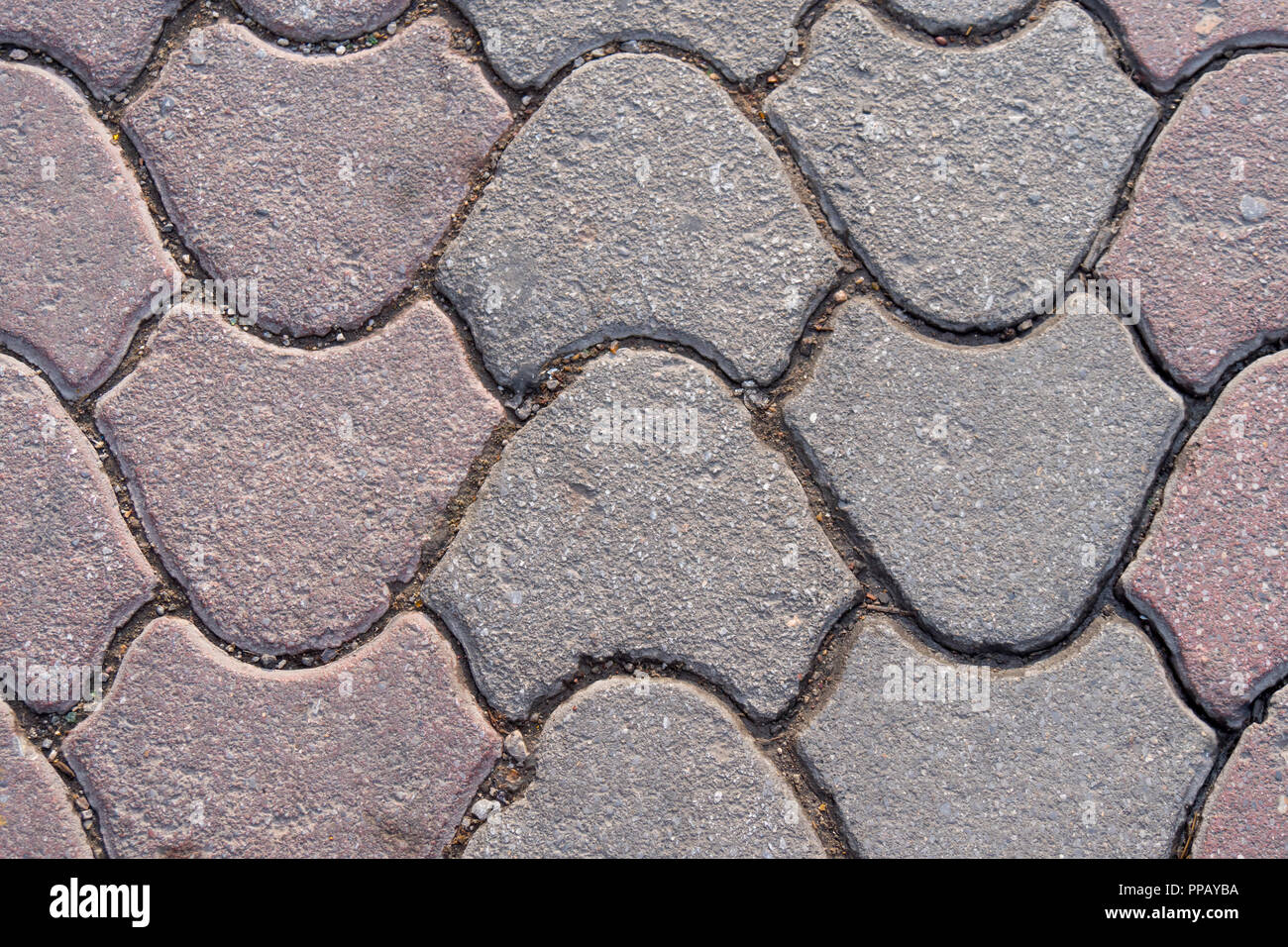 Bloc de ciment gris et rose sur le trottoir, le pavage de la rue, et la texture de fond de la dalle, on fixe le carrelage des trottoirs. Banque D'Images
