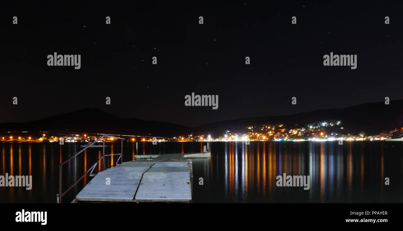 Jetée de la mer la nuit ; refléter les lumières dans l'eau Banque D'Images