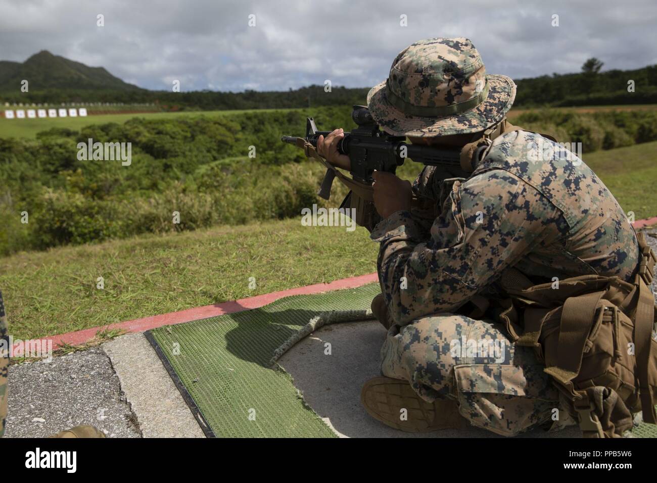 Le Cpl. Justin Lara applique les principes fondamentaux de la prise de vue en position assise au cours d'un Combat l'adresse au tir bien sûr les entraîneurs au Camp Hansen, Okinawa, Japon, 14 août 2018. Lara, originaire d'Austin, Texas, est un carabinier avec 2e Bataillon, 3e Régiment de Marines. "Je pense que les fondamentaux sont importants, parce qu'ils peuvent vous conduire de sharpshooter à expert," dit-il. "Si vous êtes grand à la base, il peut changer beaucoup de choses." Lara a dit qu'il jouit de la cours parce qu'il considère le coaching comme un excellent moyen d'aider les Marines à devenir de meilleurs tireurs. Banque D'Images