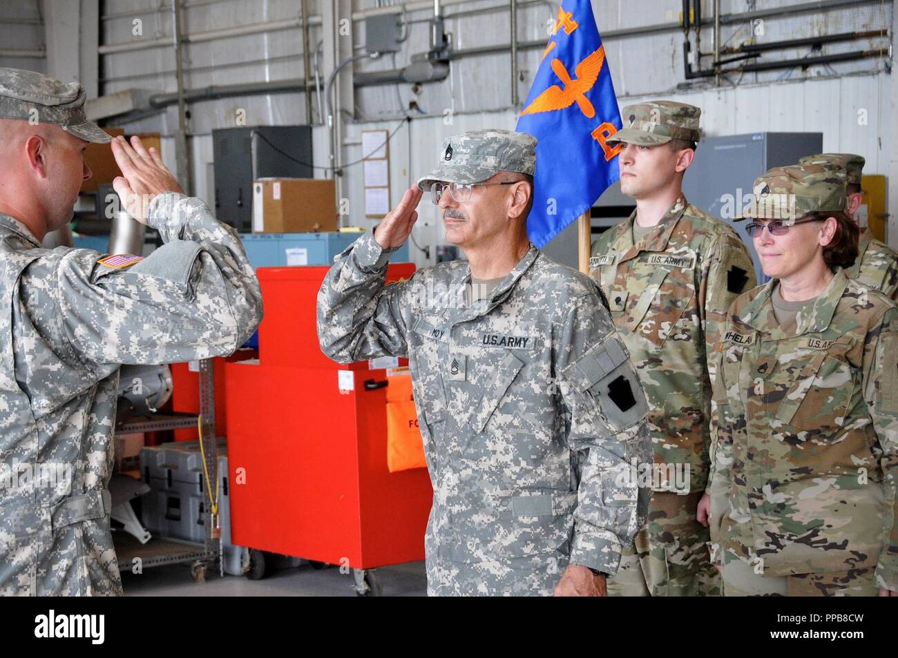 Le sergent de l'armée américaine. 1re classe Mike Moy, centre, chef d'équipage avec détachement 1, la Compagnie Bravo, 1-224ème régiment d'aviation, 28e Brigade d'aviation de combat expéditionnaire, salue le capitaine Blake Kane lors d'une cérémonie de promotion dans l'honneur à Moy Muir Army Airfield, le 18 août 2018. Le Sgt. 1re classe Moy est le plus ancien soldat actuellement dans le Connecticut Garde Nationale. Banque D'Images