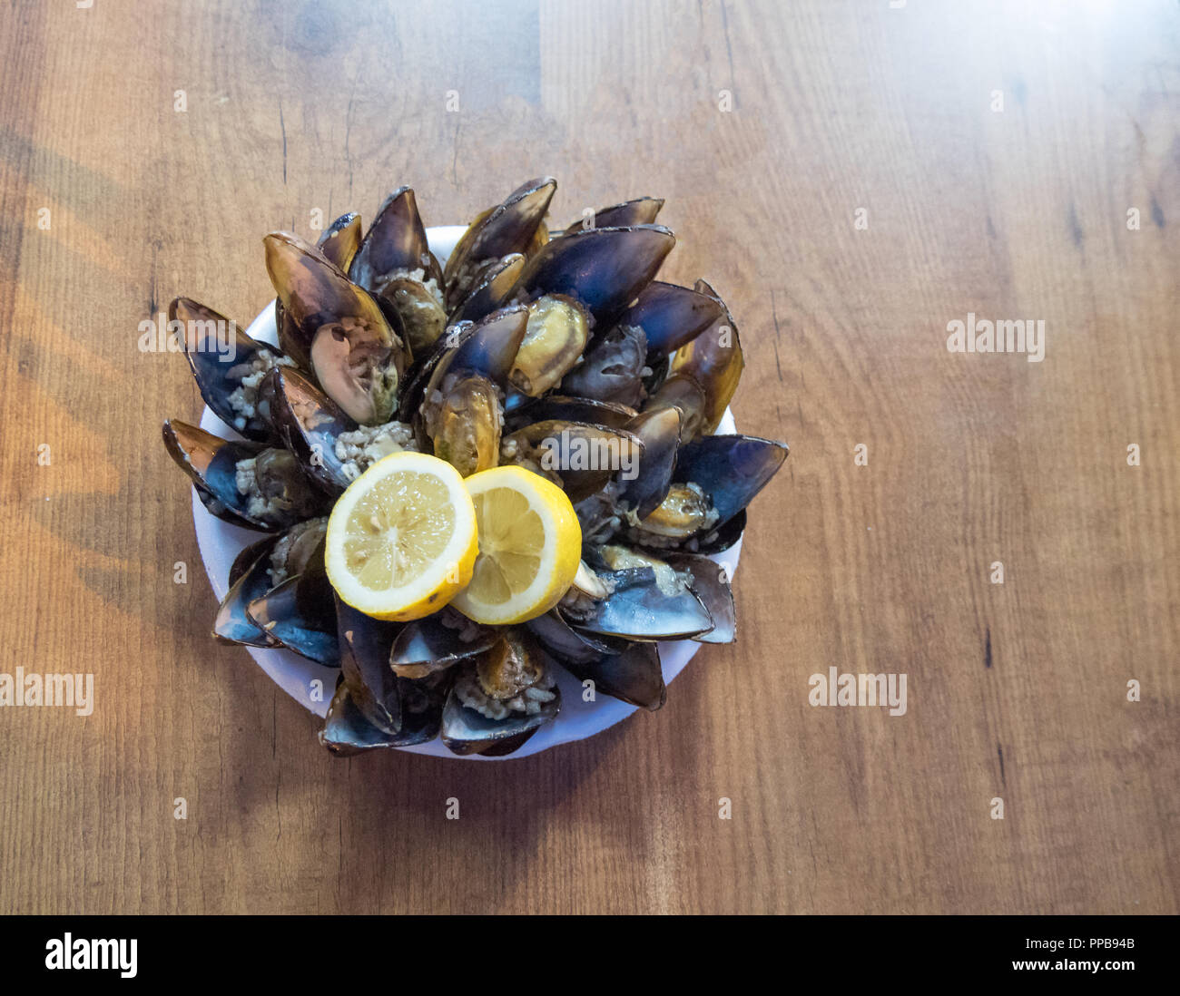 Plat de fruits de mer ouverte et prête les moules avec citron sur la table Banque D'Images