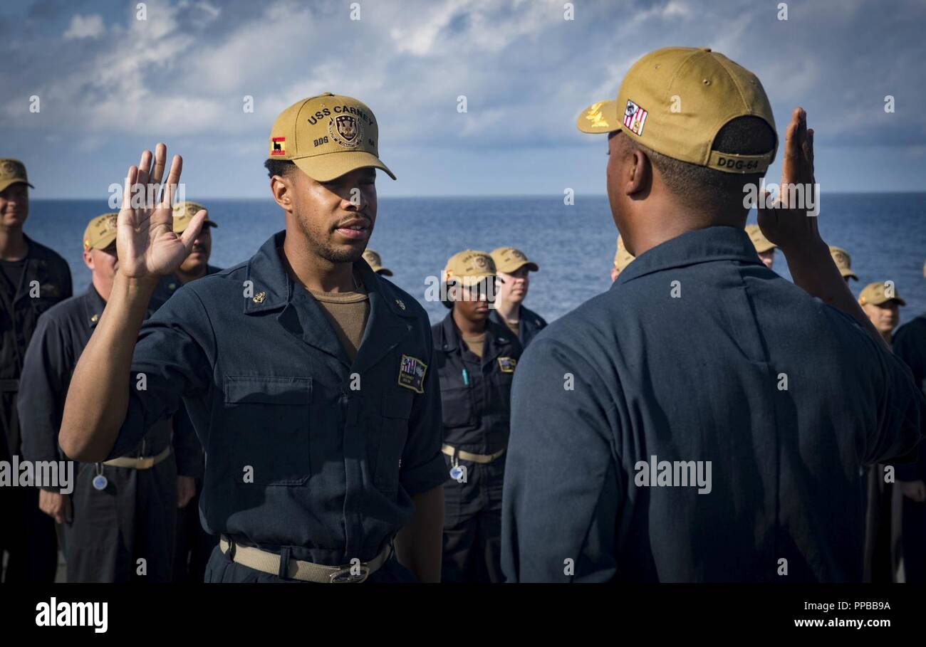 Mer (Aug. 21, 2018) Le Cmdr. Chris Carroll, directeur général de la classe Arleigh Burke destroyer lance-missiles USS Carney (DDG 64), rend le serment de réinscription au technicien de systèmes d'information en chef Tyrone Davis le 21 août 2018. Carney, l'avant-déployé à Rota, en Espagne, est sur sa cinquième patrouille dans la sixième flotte américaine zone d'opérations à l'appui d'alliés et de partenaires régionaux ainsi que les intérêts de sécurité nationale des États-Unis en Europe et en Afrique. Banque D'Images