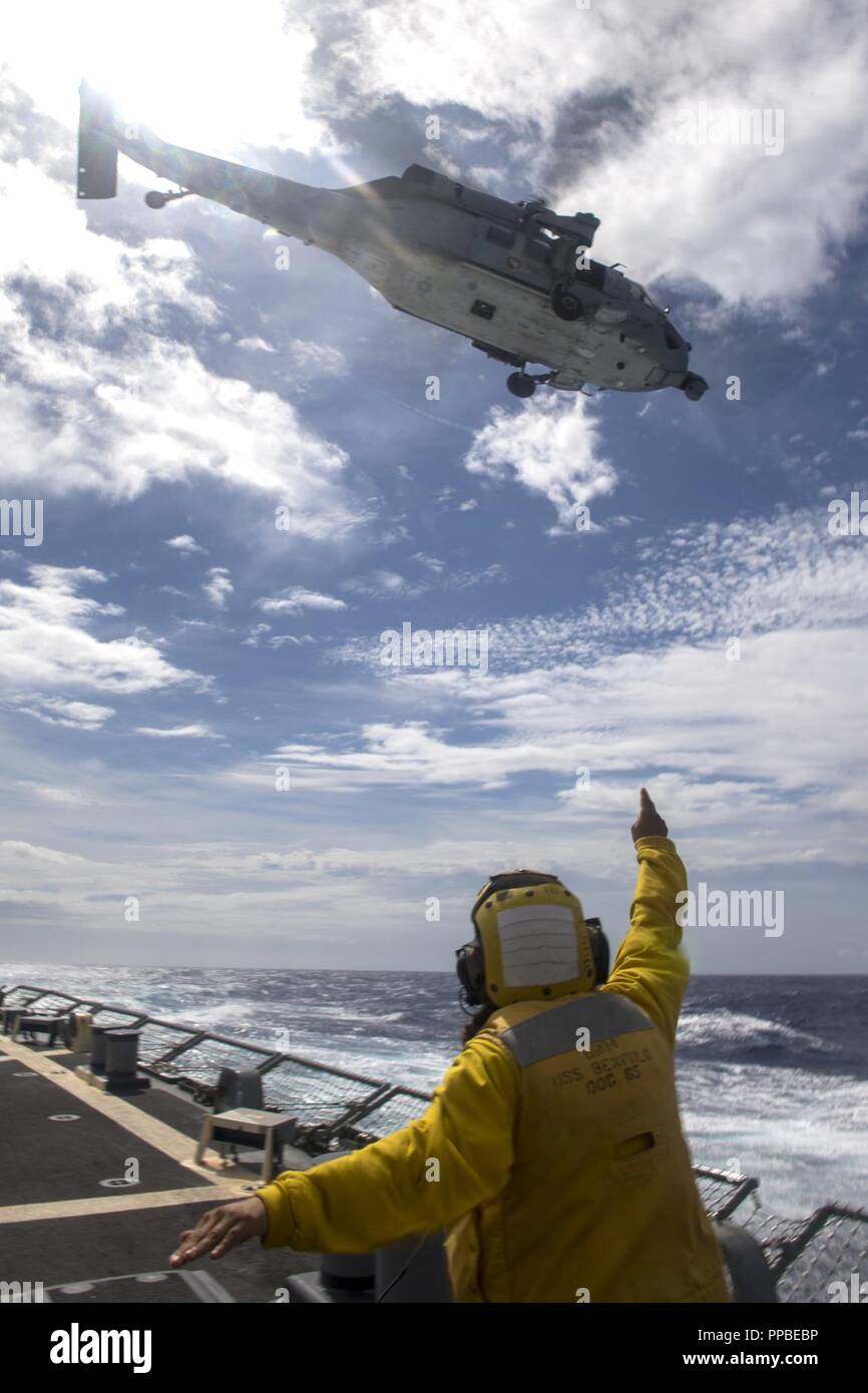 Mer des Philippines (16 août 2000 23, 2018) Maître de Manœuvre 2e classe Flores-Caballero Fatima, de Cleburne (Texas), les signaux d'un MH-60S Sea Hawk affecté à l'hélicoptère de faucons d'or de l'Escadron de Combat de mer (HSC) 12 qu'il décolle de l'envol de la classe Arleigh Burke destroyer lance-missiles USS Benfold (DDG 65). Benfold est l'avant-déployés dans la 7e flotte américaine zone d'opérations à l'appui de la sécurité et de la stabilité dans la région Indo-Pacifique. Banque D'Images