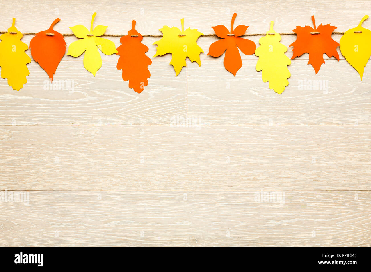 Simple et rustique de style automne décorations Thanksgiving garland bannière de couper les feuilles de papier coloré sur fond en bois blanc Banque D'Images