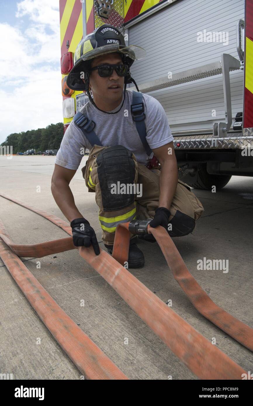 Les cadres supérieurs de l'US Air Force Airman Kula Funn, pompier, avec le 624th squadron de l'Ingénieur Civil Joint Base Harbor-Hickam Pearl, Mississippi, organise un tuyau d'incendie en vue de la prochaine formation incendie simulé au cours de l'événement guerrier patriote 2018 à Dobbins Air Reserve Base, la Géorgie, le 17 août, 2018. Préparer des exercices de guerrier patriote citoyen réserve expéditionnaire aviateurs pour les déploiements à l'échelle mondiale et fournit des connaissances et l'expérience pour renforcer les programmes de formation à la maison mère. Banque D'Images