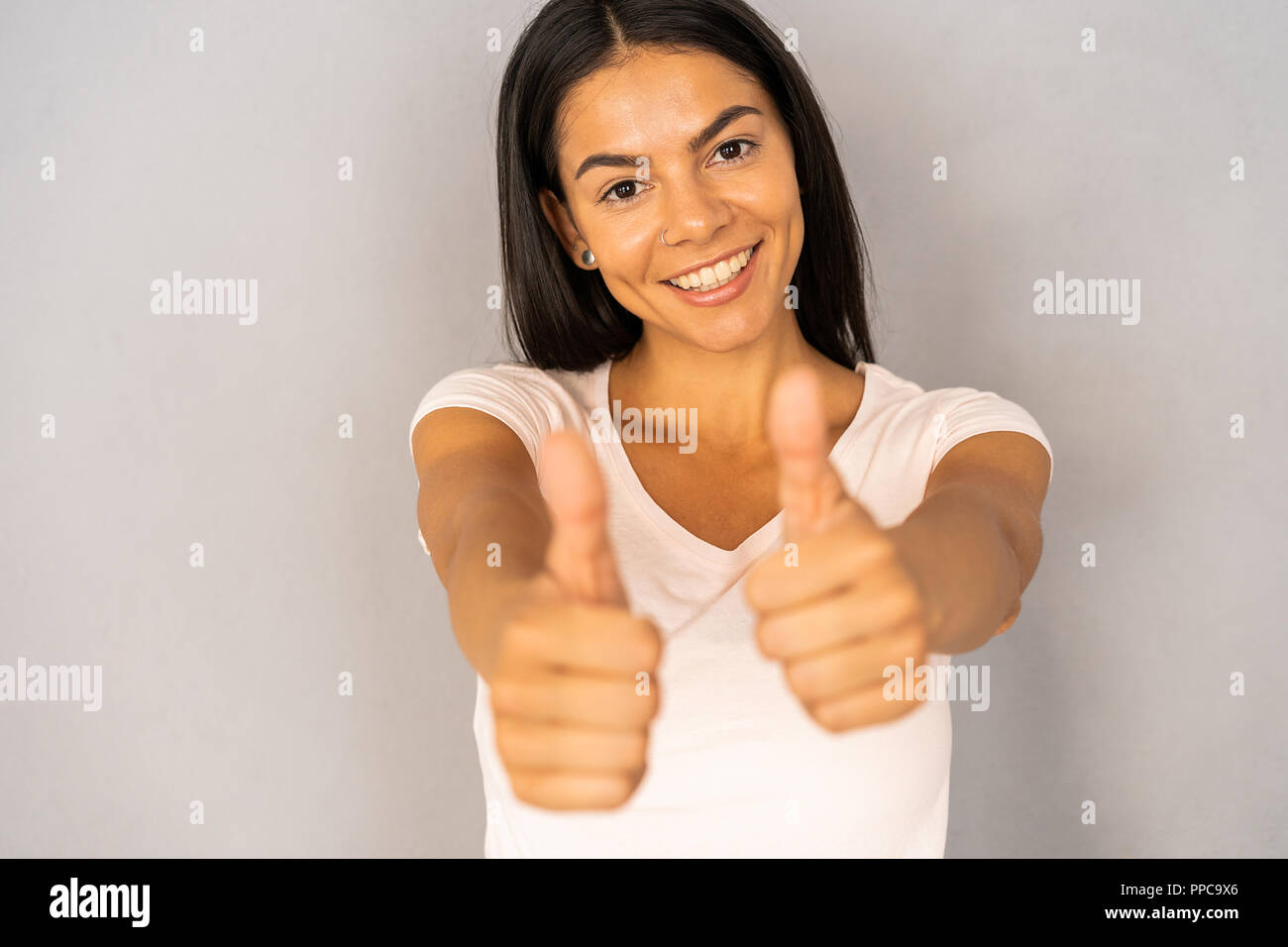 Young happy cheerful woman showing thumb up. Banque D'Images
