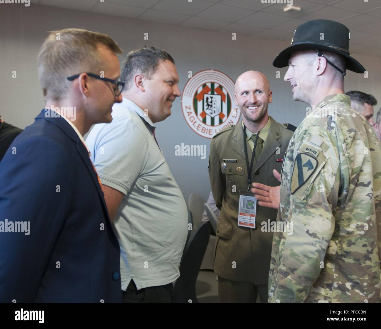 Le Lieutenant-colonel de l'armée américaine Matthew Rogers, à droite, le commandant du 91ème bataillon du génie, 1re Brigade de blindés de combat, l'équipe de 1re Division de cavalerie, se réunit avec Marcin Chludziński, le président de KGHM Pologne le cuivre et commanditaire de l'équipe de soccer Zagłębie Lubin, au cours de la soirée de reconnaissance tenue à l'KGHM Zagłębie Lubin Soccer Stadium à Lubin, Pologne, le 12 août 2018. Le Major de l'armée polonaise Jacob Wołynski, centre, le directeur sportif avec le 23e Régiment d'artillerie, a organisé l'événement avec l'aide de Mateusz Dróżdż, gauche, le chef de l'équipe de soccer Zagłębia Lubin, en l'honneur de Polish Banque D'Images