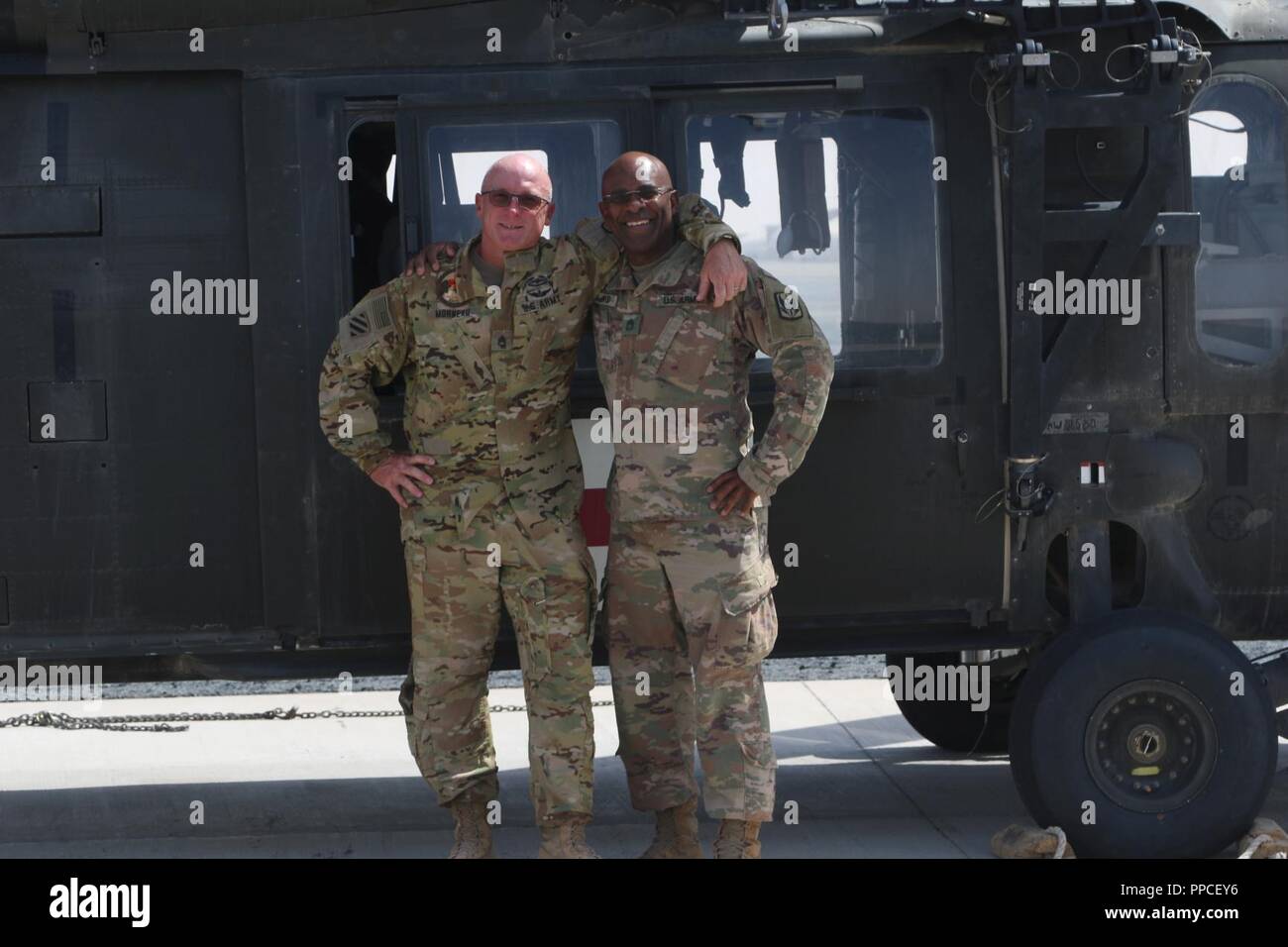 CAMP BUEHRING, Koweït - U.S. Army Staff Sgt Robert Morneau (à gauche), chef d'équipe affectée au 1er Bataillon, 126e Régiment d'aviation (soutien général Aviation Battalion) pose pour une photo avec le Sgt 1re classe Giovanni Ford, la 449e Brigade d'aviation de combat et de l'Administration centrale de l'offre de la société sergent en face d'un UH-60 Blackhawk 21 Août, 2018. Les deux sous-officiers sont l'enfance camarades qui n'ont pas vus pendant 30 ans jusqu'à ce qu'ils se mélangent dans leur déploiement 2017-2018 à l'appui d'opérations inhérentes à résoudre et Bouclier spartiate. Banque D'Images