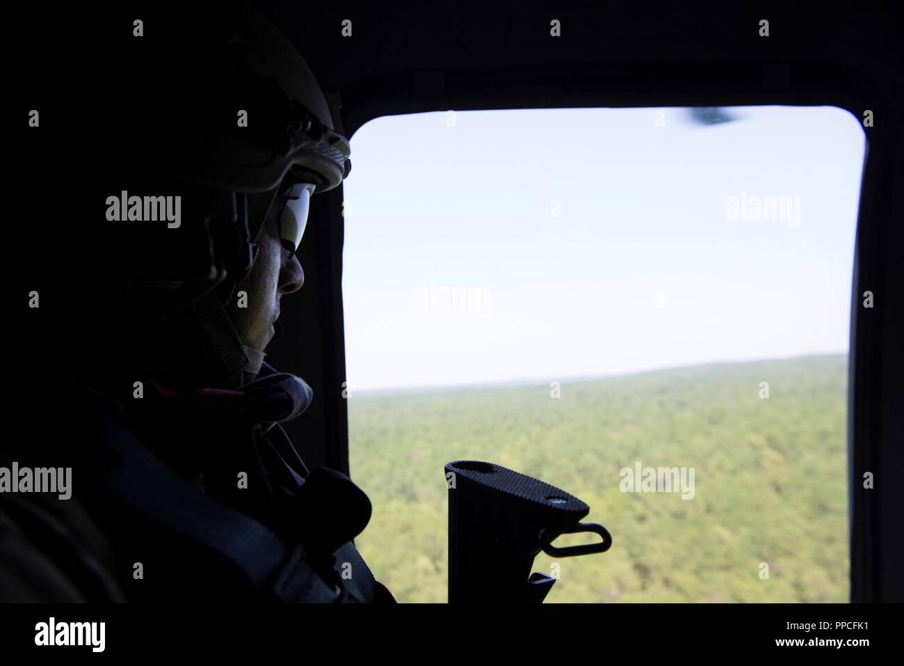 Les cadres supérieurs de l'US Air Force Airman Elias Omar, 20e Escadron de Génie Civil des explosifs et munitions compagnon, regarde par la fenêtre d'un UH-60 Black Hawk affecté à la base de la Garde nationale mixte Guess, S.C., plus de Colombie-Britannique, L.C. (23 août, 2018. L'hélicoptère a été le dernier événement dans un exercice de quatre jours ont participé à Omar. Banque D'Images