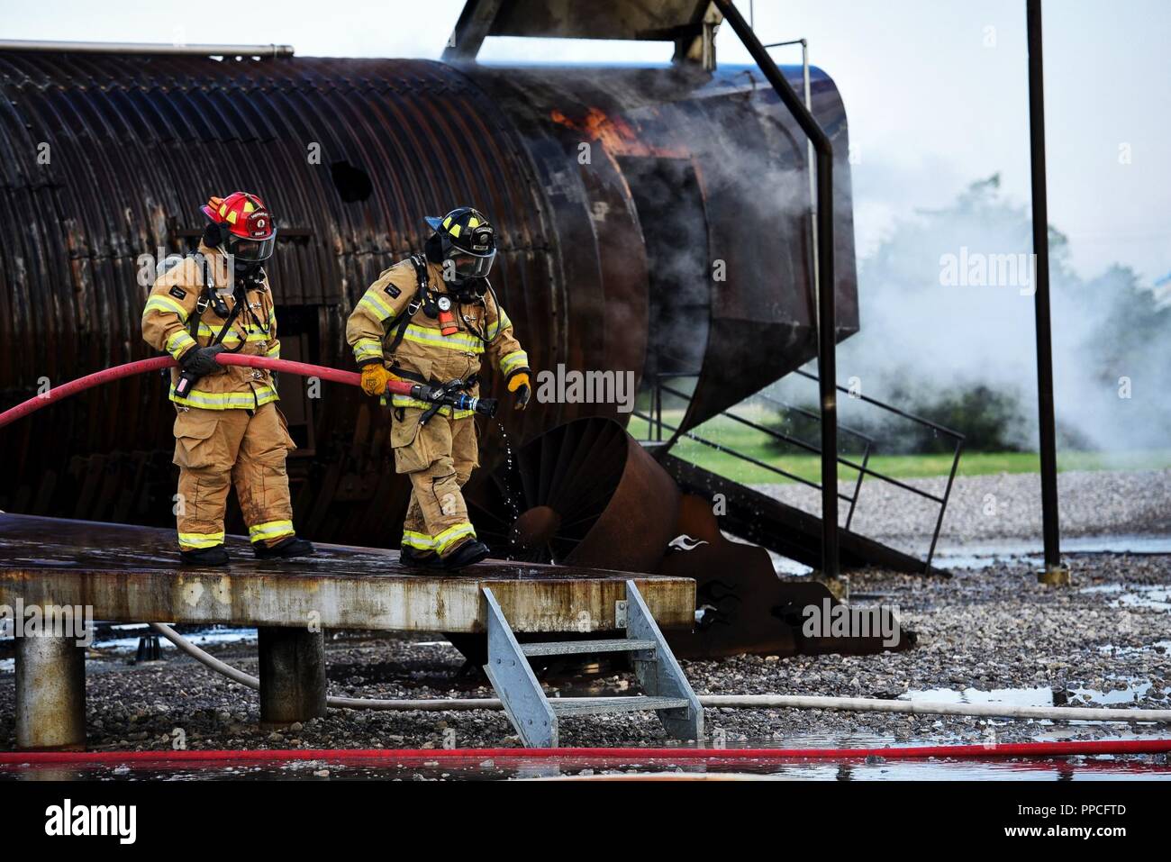 Les pompiers de la Base Aérienne de Sheppard sortie du service d'incendie une maquette d'un avion après l'extinction d'un incendie dans le cadre de leurs exercices de tir réel à Sheppard Air Force Base, Texas, le 23 août, 2018. Le ministère effectue de fréquentes séances de formation pour actualiser les compétences nécessaires des pompiers différents y compris la lutte contre les incendies d'aéronefs extérieur et intérieur ainsi que les incendies de moteur. Banque D'Images