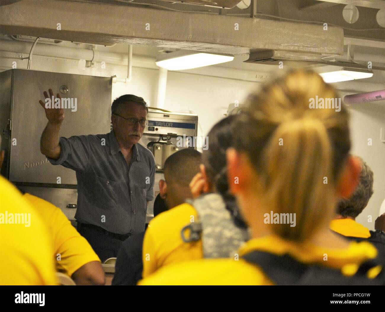 Les CTF(SW) Thomas Dandes (Ret.), le coprésident pour la 18e édition de la CPO Journées du patrimoine formation, a présenté une première personne compte des actions de l'eau Chef fatidique adjudication Peter Tomich, qui ont péri à bord du USS California (BB-31/AG-16) au cours de l'attaque sur Pearl Harbor le 7 décembre 1941. Dandes si la présentation dans le mess des officiers en chef à bord du USS Wisconsin (BB-64), un espace qui est généralement fermé au publique. Dandes est habillée dans l'US Navy dungaree, uniforme et eu l'occasion de démontrer l'absence d'uniforme de sueur wicking capacités. L'hôtel Hampton Roads Naval M Banque D'Images
