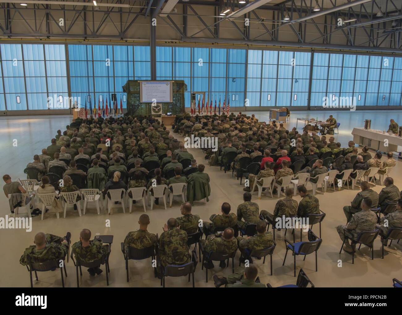 United States Air Force aviateurs se rassembler avec l'OTAN et de pays partenaires dans le hangar d'entretien pour les séances d'ouverture de l'exercice 2018 Grève amplement à Namest Air Base, République tchèque. Grève amplement est une République Tchèque, conduite, multi-nationale qui offre des exercices réels advanced air/terre intégration formation à la finale de l'attaque conjointe des contrôleurs (JTACs) et l'appui aérien rapproché (CAS) d'équipage. L'exercice met en lumière les États-Unis et nos alliés de l'OTAN et les pays partenaires engagement à défendre l'intégrité territoriale de l'Europe. Banque D'Images