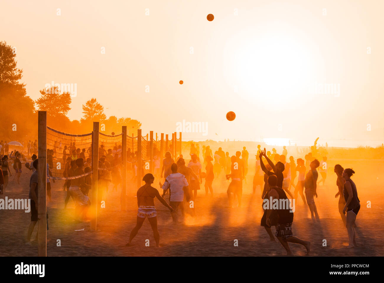 Grand groupe de personnes à jouer au volleyball de plage au coucher du soleil sur les banques espagnoles, Vancouver, British Columbia, Canada Banque D'Images