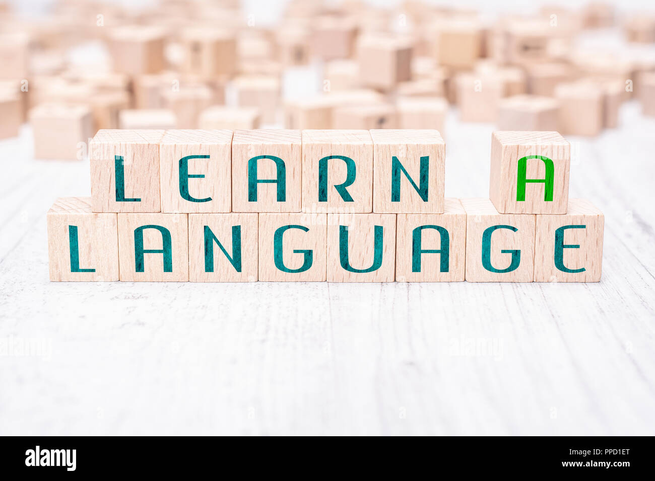 Les mots Apprendre une langue formée par des blocs de bois sur un tableau blanc Banque D'Images