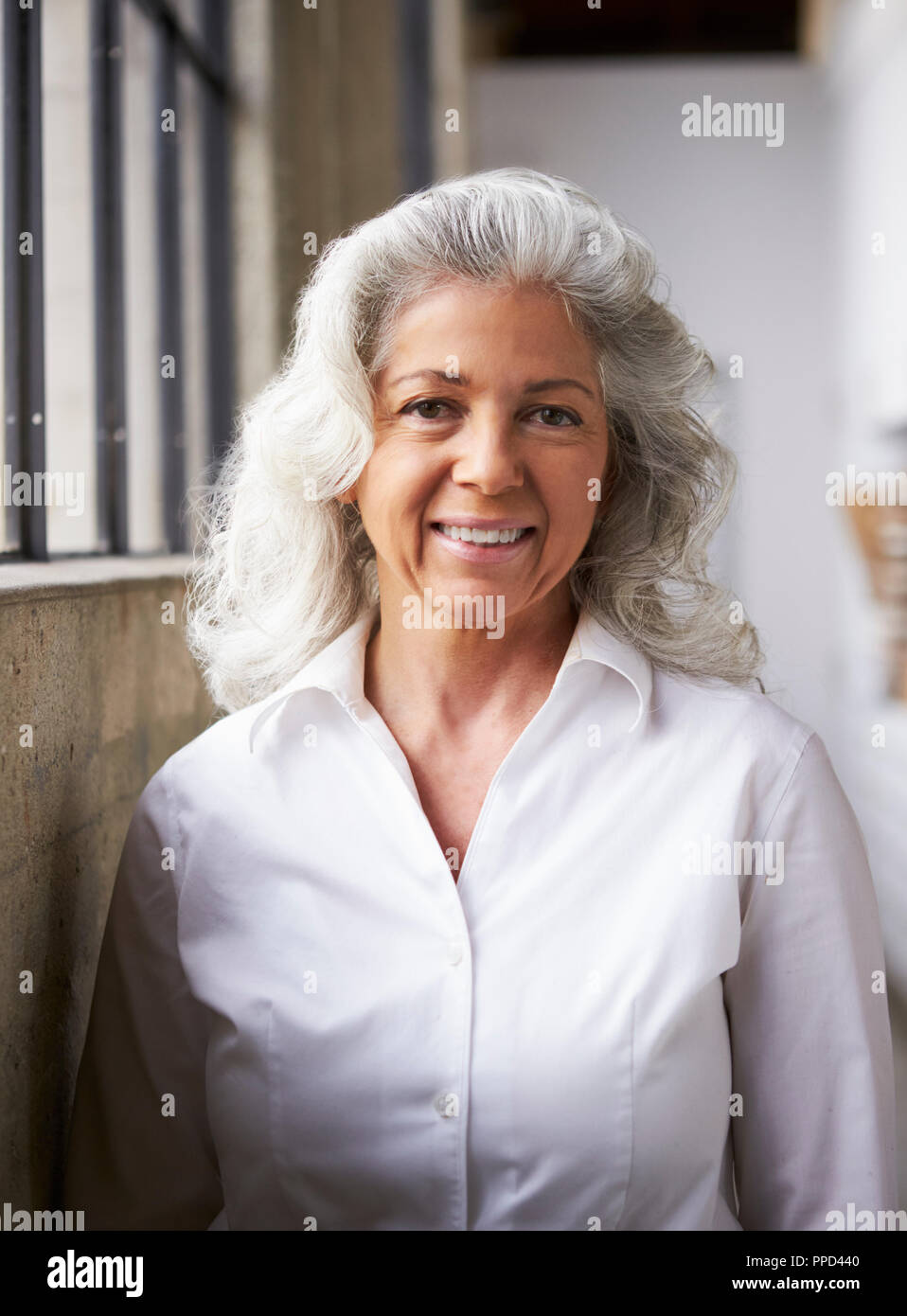 Blanc Senior businesswoman en chemise blanche, verticale Banque D'Images