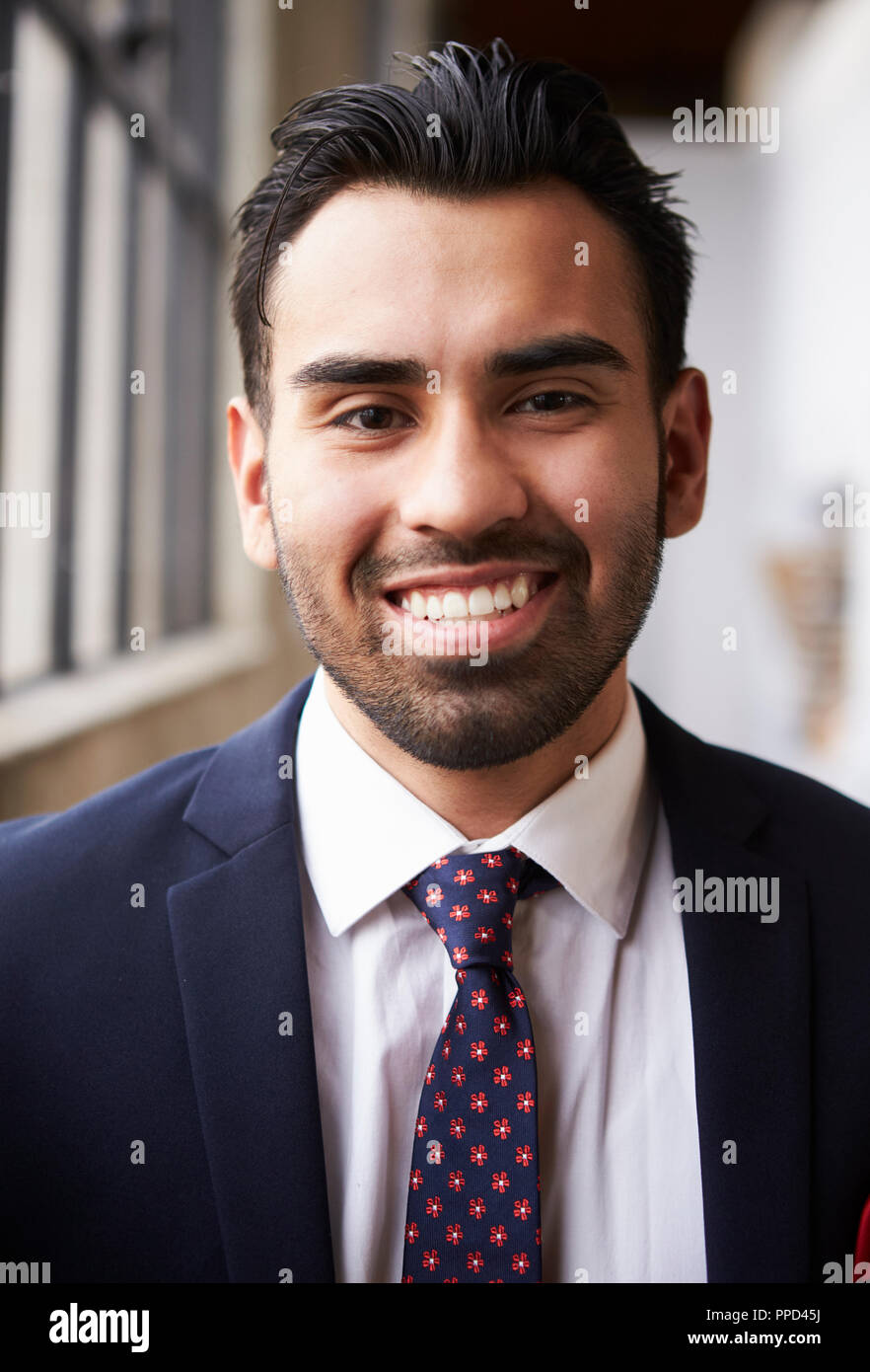 Young Hispanic businessman smiling to camera, vertical Banque D'Images