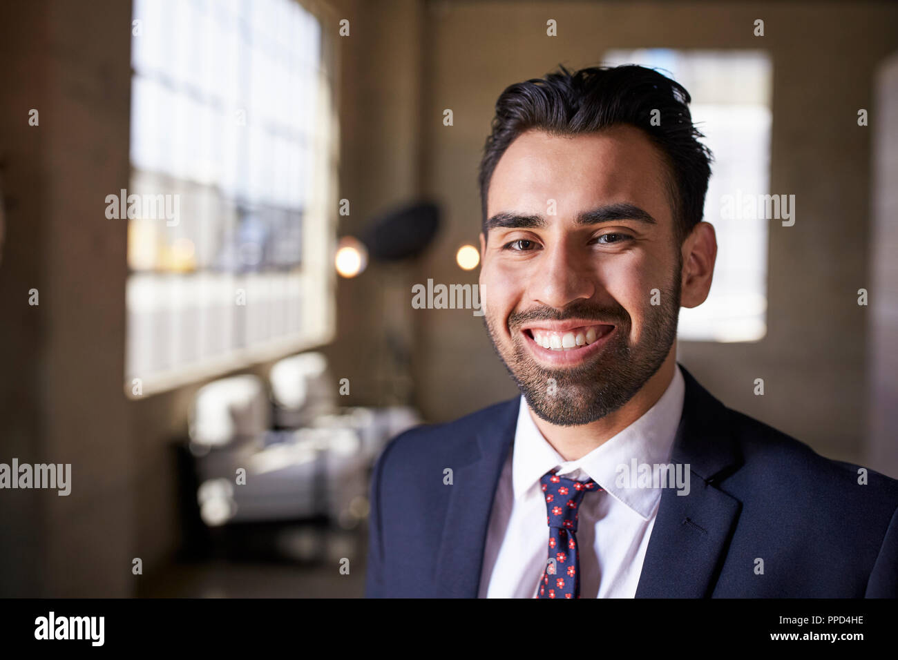 Young Hispanic businessman smiling to camera, Close up Banque D'Images