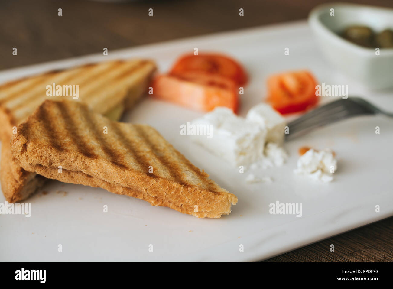 Panini grillé et pressé avec fromage servi sur la plaque sur une table en bois. Banque D'Images