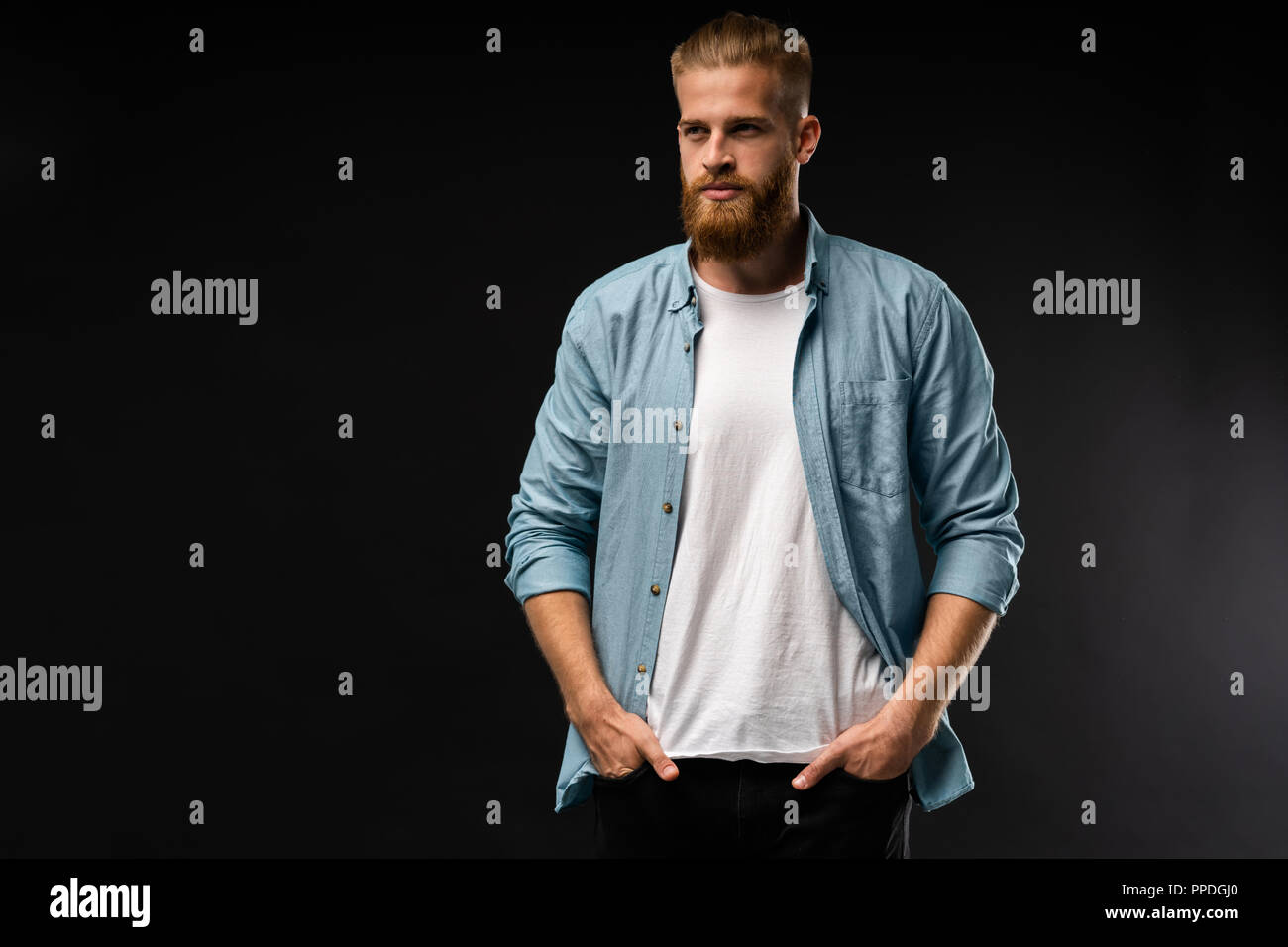 Portrait of fashionable bel homme en jeans shirt regarder la caméra. Banque D'Images