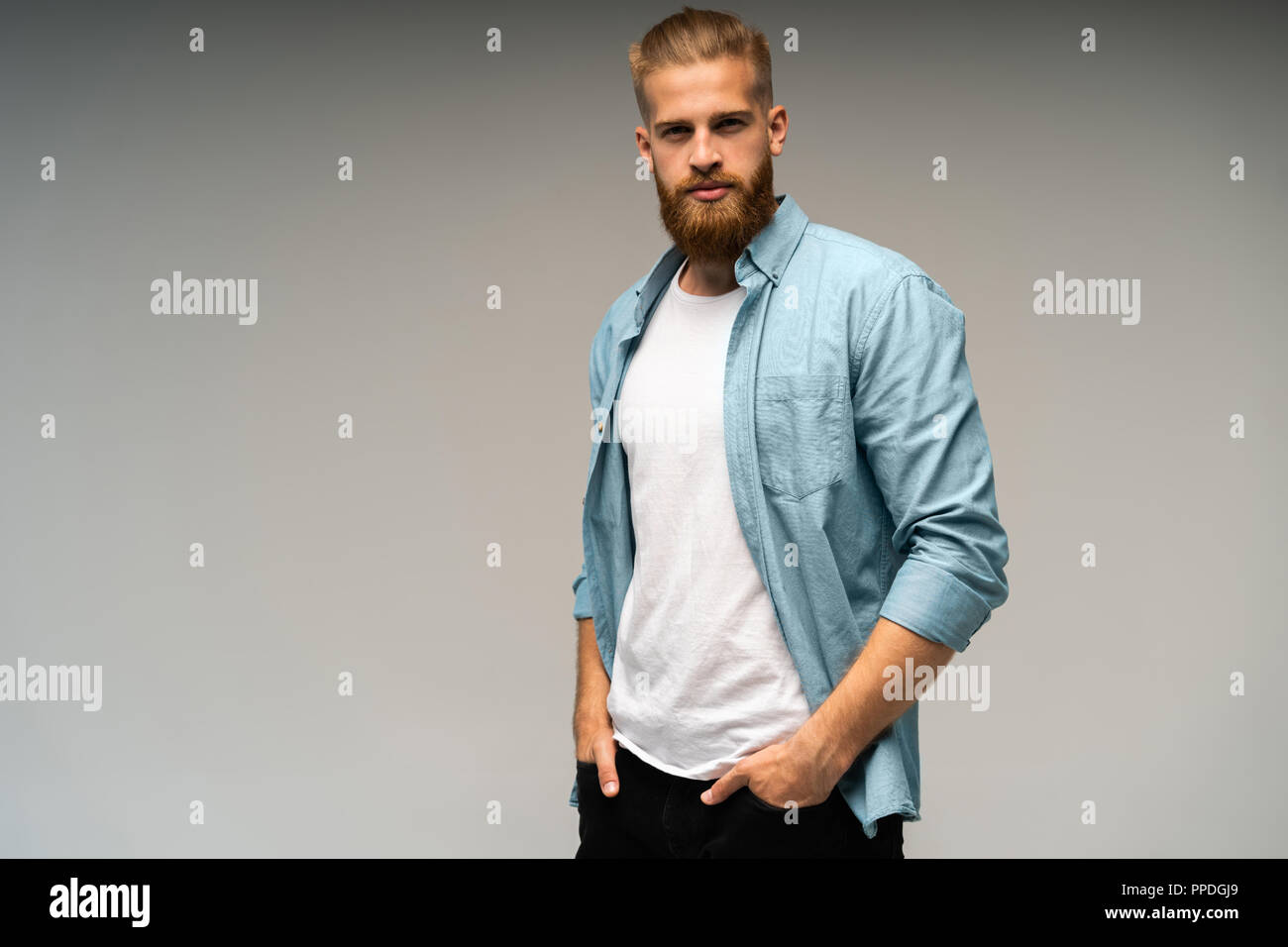 Portrait of fashionable bel homme en jeans shirt regarder la caméra. Banque D'Images