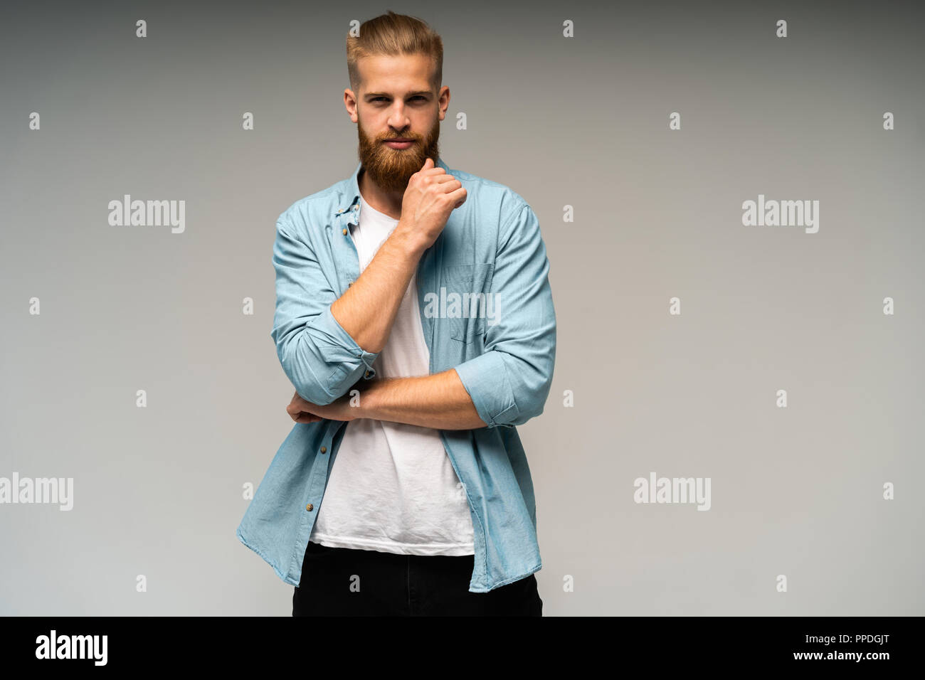 Portrait of fashionable bel homme en jeans shirt regarder la caméra. Banque D'Images