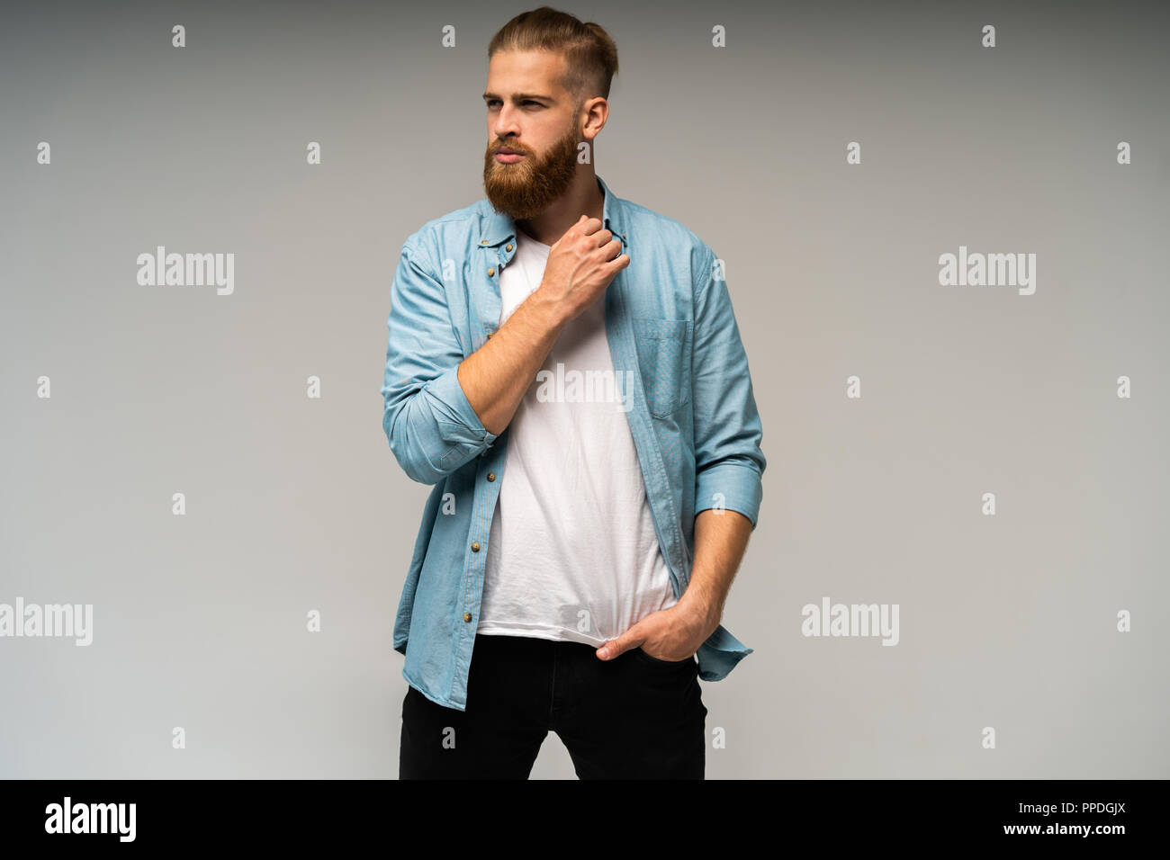 Portrait of fashionable bel homme en jeans shirt regarder la caméra. Banque D'Images