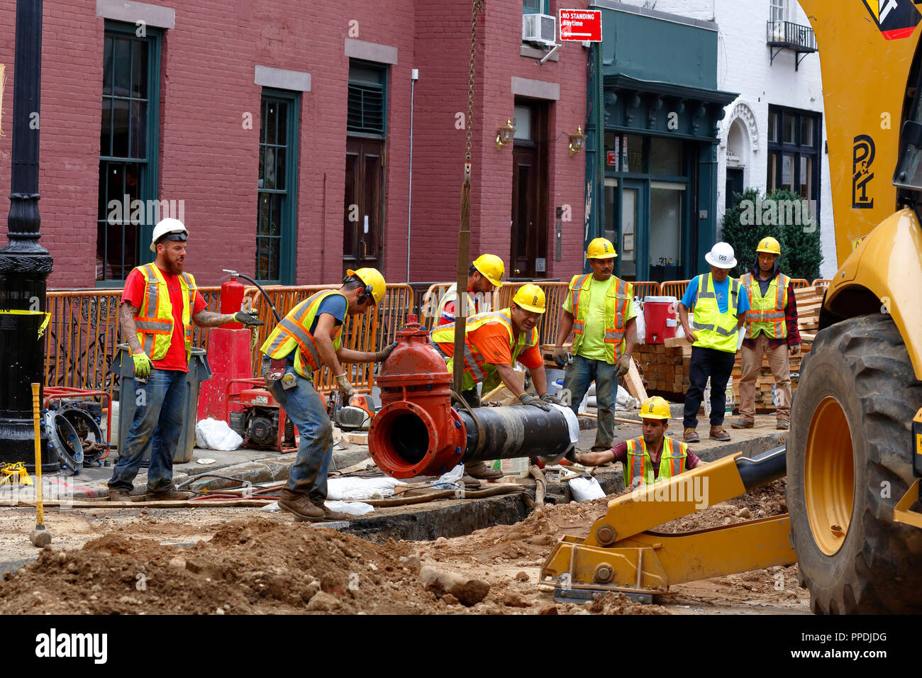 Les ouvriers de la construction abaissent une vanne d'entrée principale d'eau dans une tranchée qui sera installée dans le système d'approvisionnement en eau de la ville. New York, 20 septembre 2018 Banque D'Images