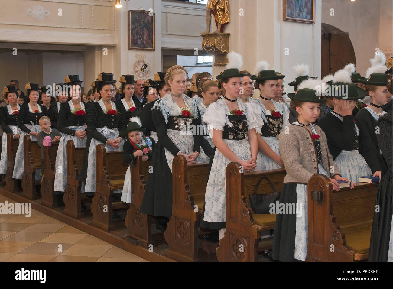 Le Trachtenverein (costumes) club d'Raschenberger Teisendorf pendant le service annuel en l'église de Saint Andreas Inzell. Banque D'Images