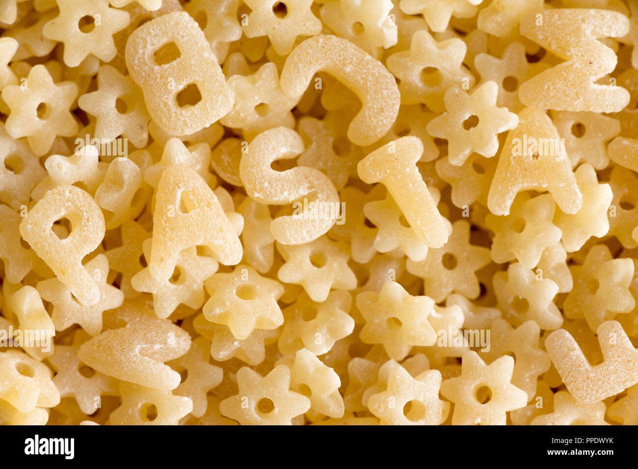 Vue rapprochée sur du sec et de l'alphabet au hasard star sans sauce pâtes en forme de l'orthographe du mot pasta Banque D'Images