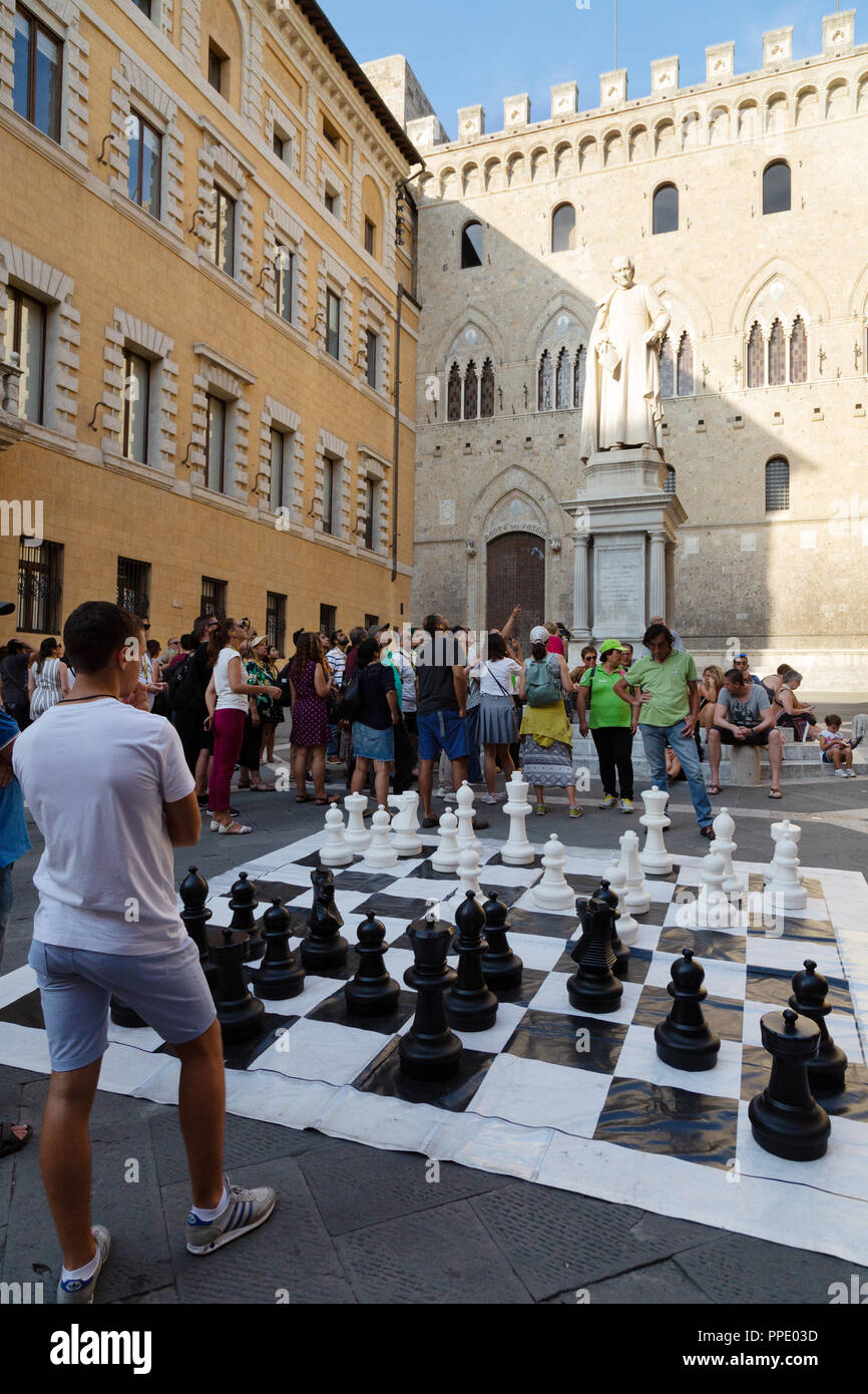 Des personnes jouant au jeu d'échecs géant en plein air, Piazza Salimbeni, Sienne, Toscane Italie Europe Banque D'Images