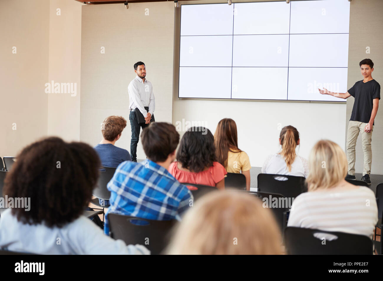 Male Student Giving Presentation de High School Class en face de l'écran Banque D'Images