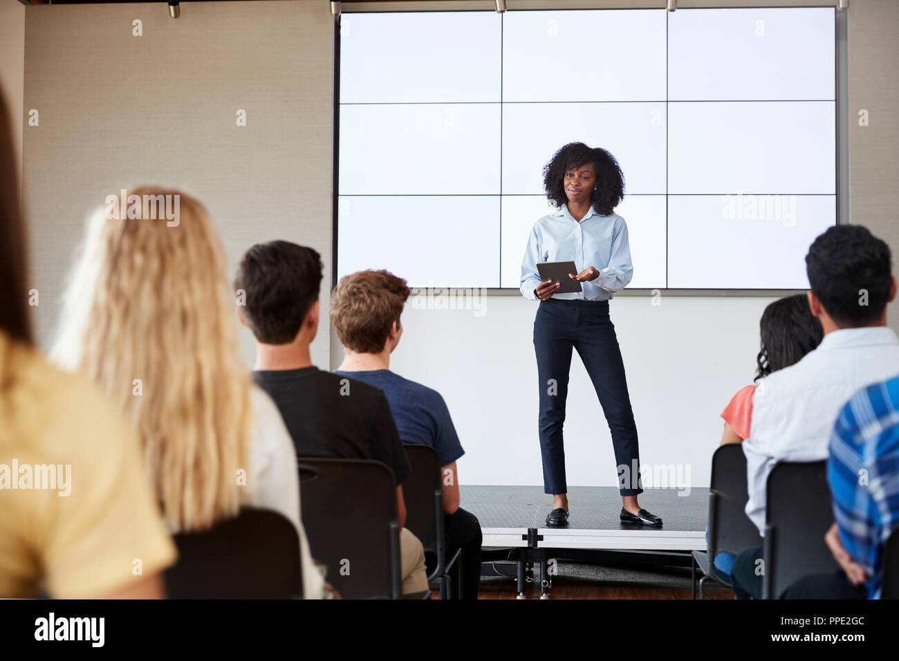 Enseignante avec tablette numérique Présentation donnant à l'école secondaire en classe d'affichage Banque D'Images