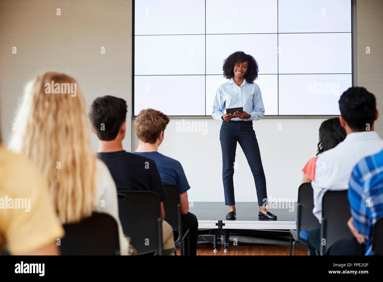 Enseignante avec tablette numérique Présentation donnant à l'école secondaire en classe d'affichage Banque D'Images