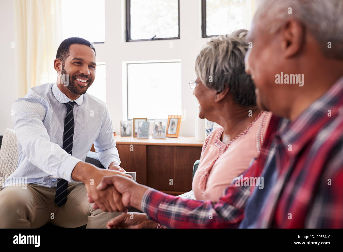 Senior Couple Shaking Hands With Male conseiller financier à la maison Banque D'Images