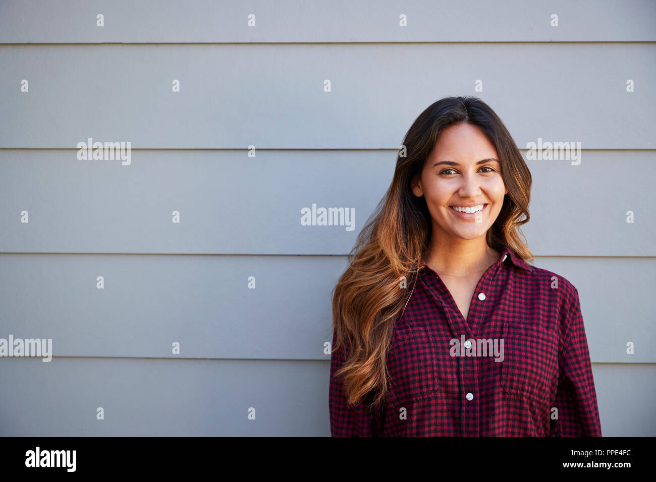 Portrait of Young Woman Standing en dehors de baraque en bois gris Banque D'Images