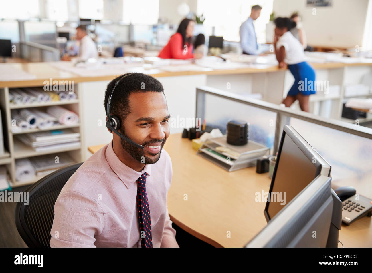 Smiling black homme travailleur de centre d'appels à l'écran à Banque D'Images
