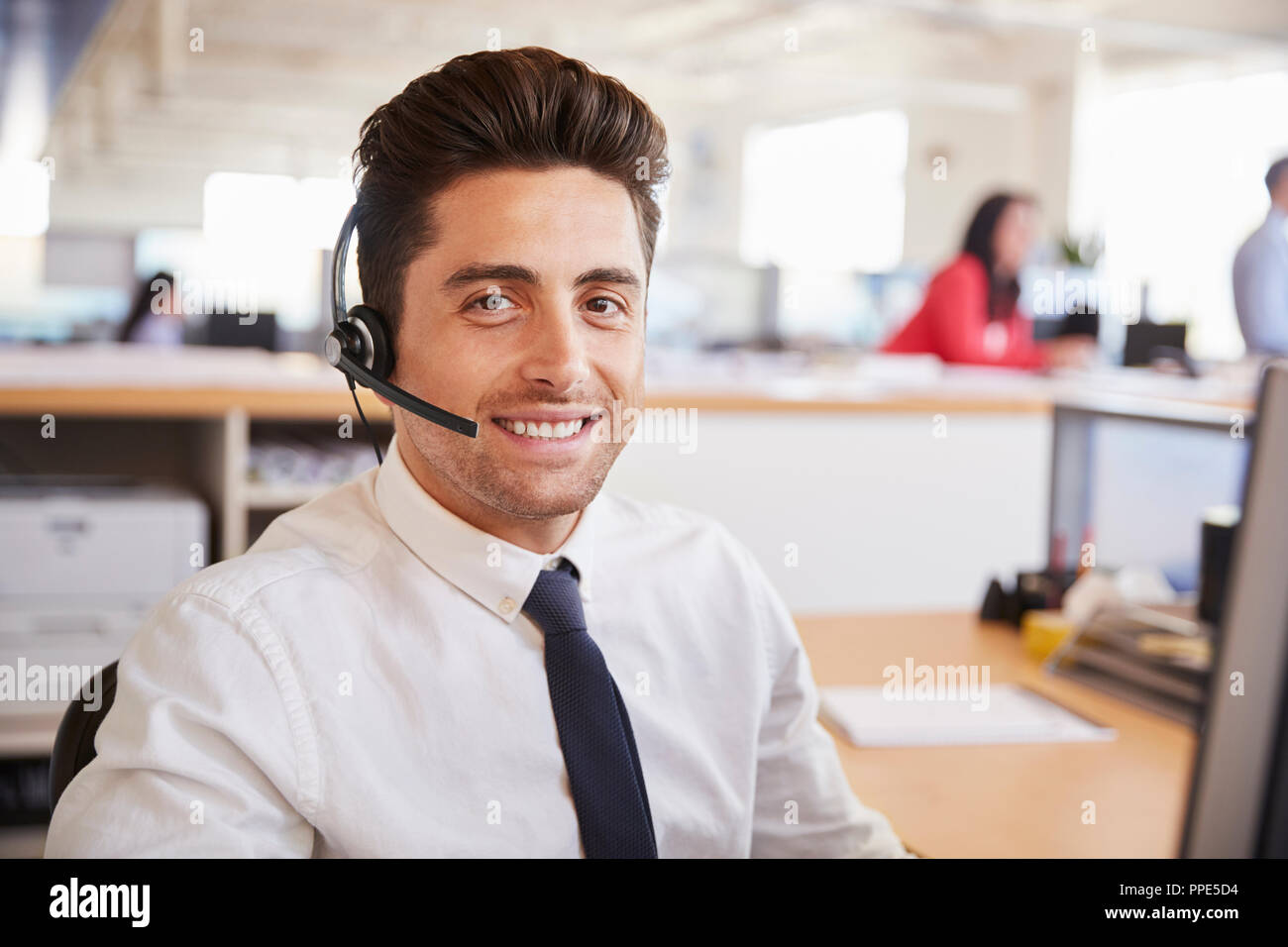 Hispanic male call center worker smiling to camera, close-up Banque D'Images