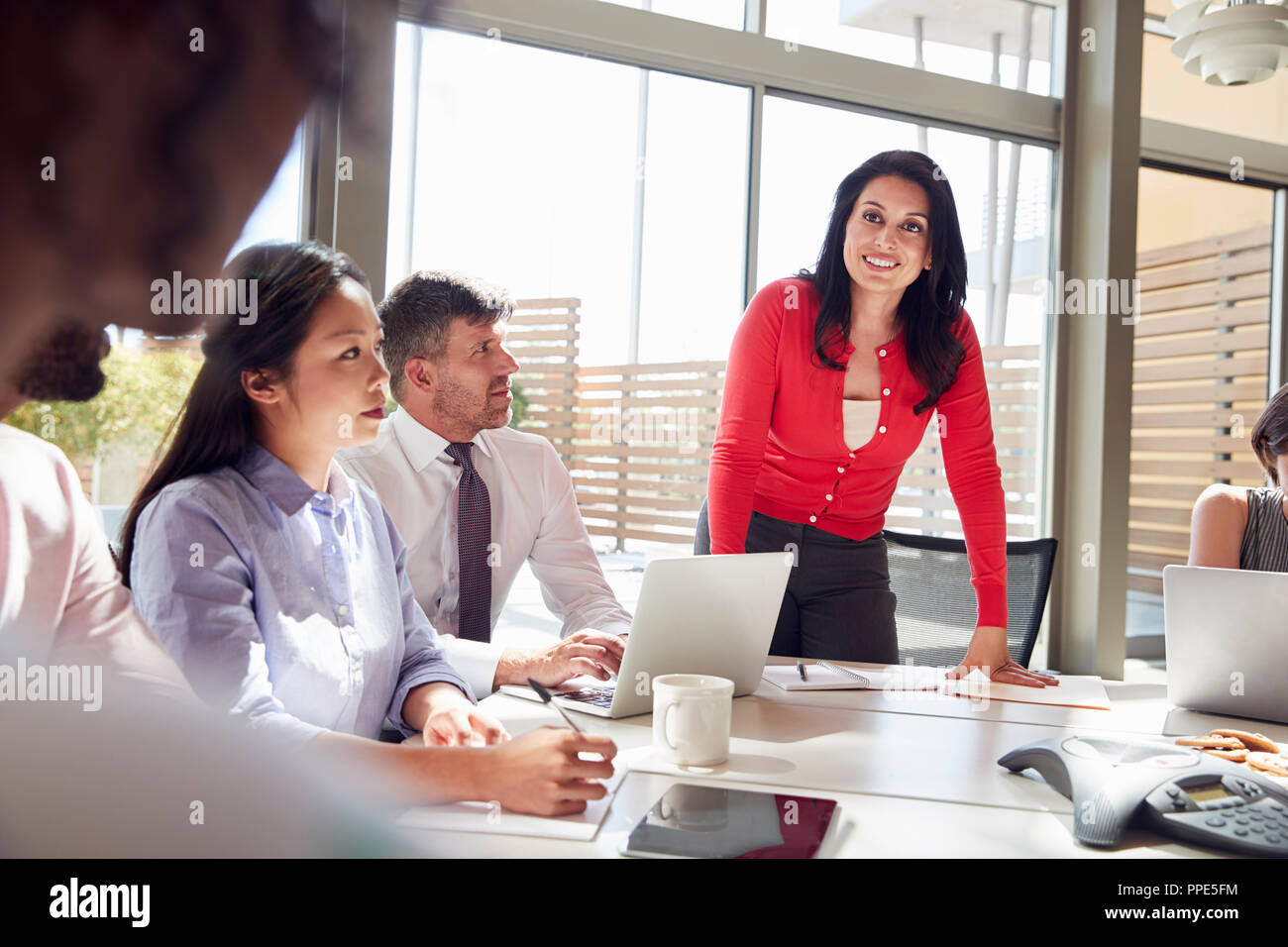 Smiling businesswoman listening to colleagues lors d'une réunion Banque D'Images